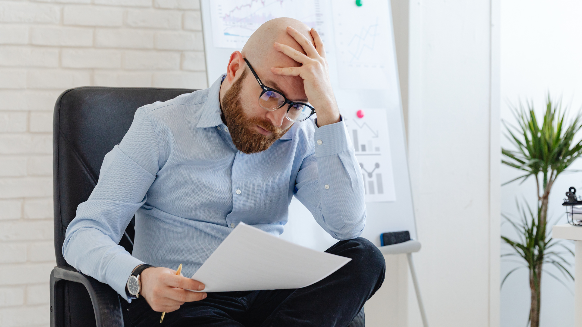 Stressed small business owner staring at an empty wallet and scattered financial papers on a desk