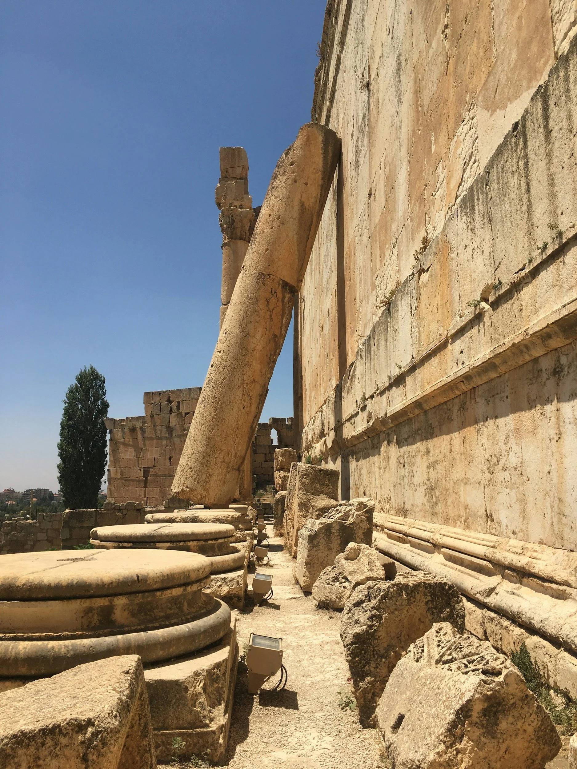 The Roman Empire dominated Jesus' people by extracting wealth. In this photograph, a large stone pillar is toppled and leaning against a wall. Even the dominators fall.