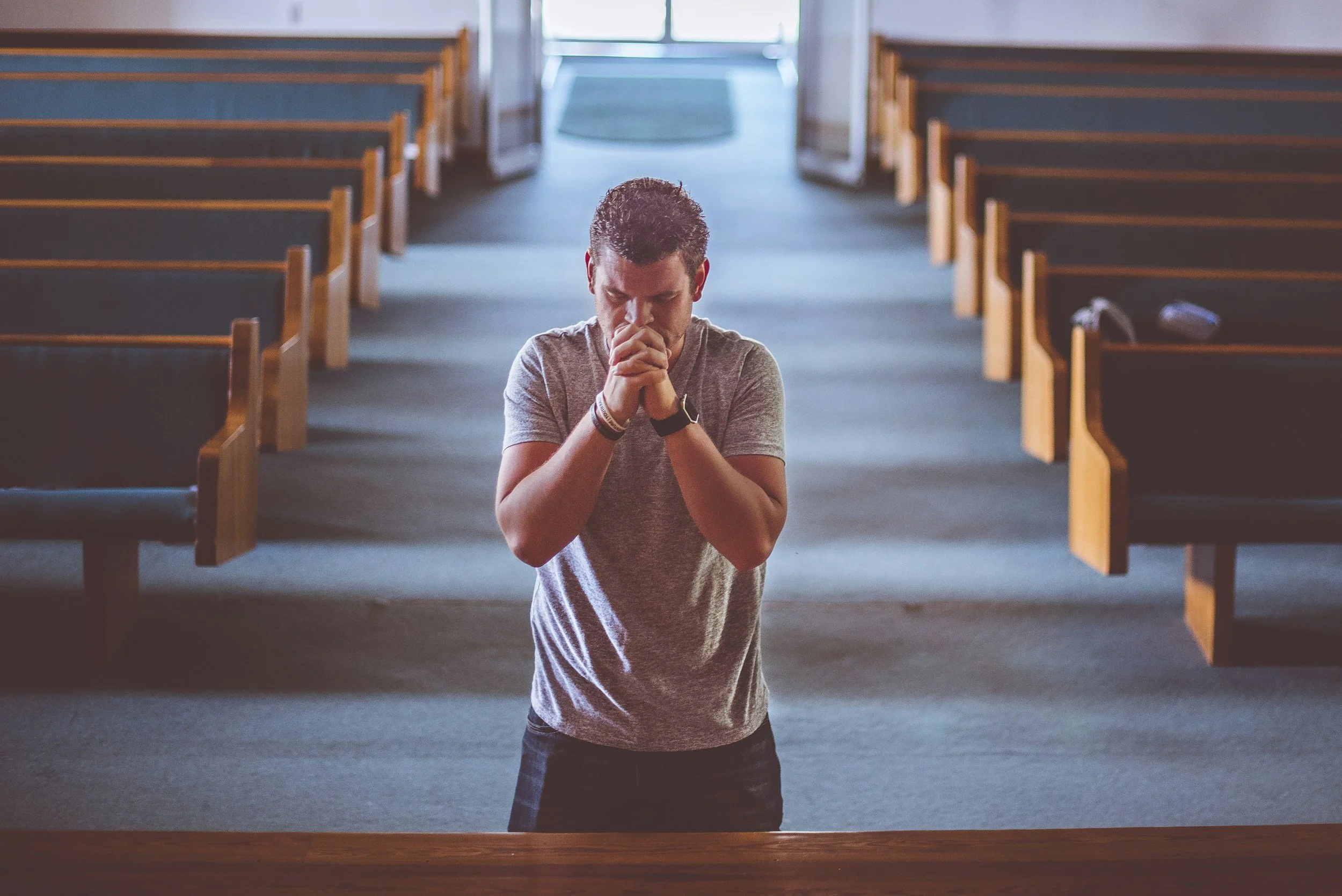 Jesus humbled himself to the will of God. He is our lasting example. This young man kneels at a church altar.