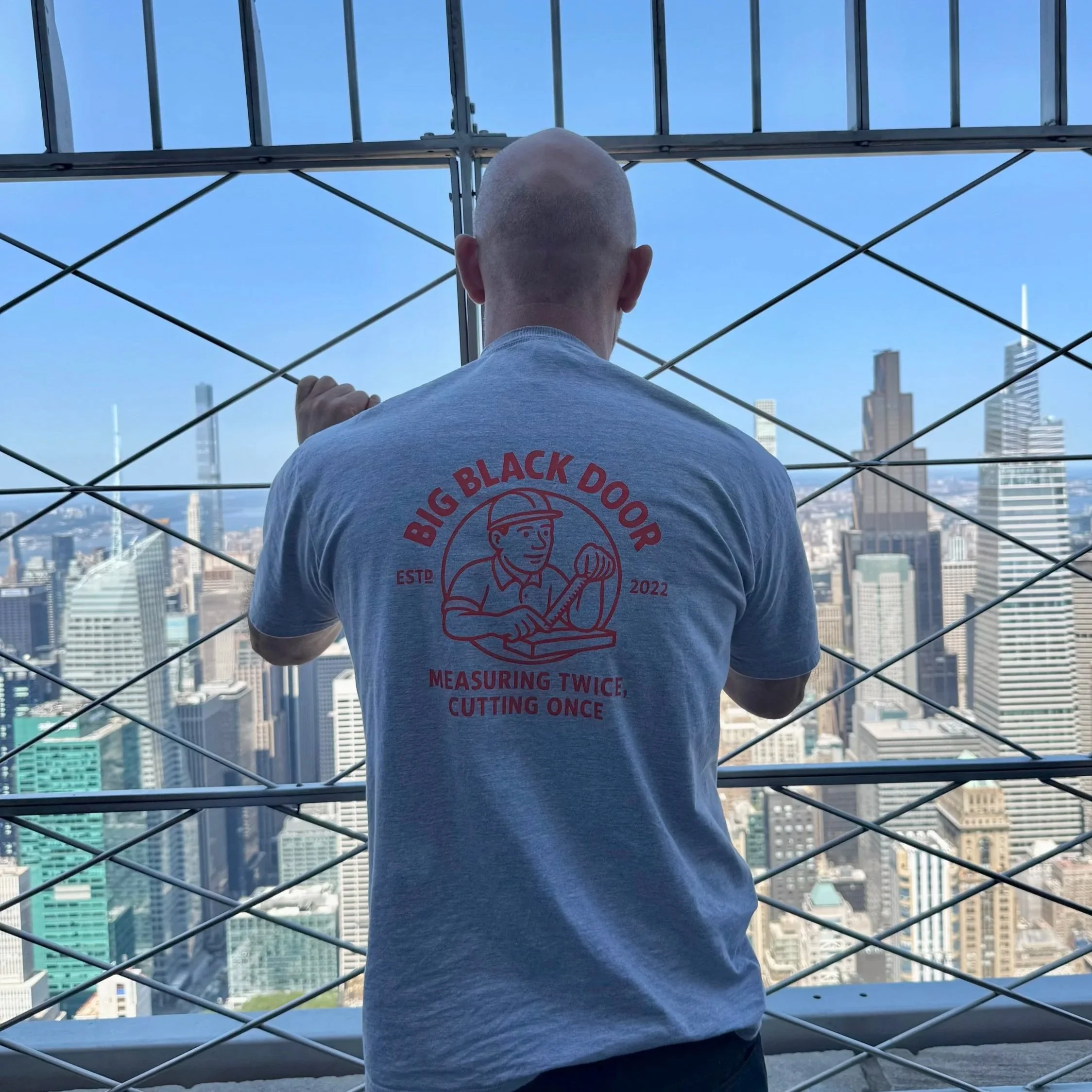 Gareth wearing a Big Black Door t-shirt at the top of the Empire State Building overlooking Manhatten