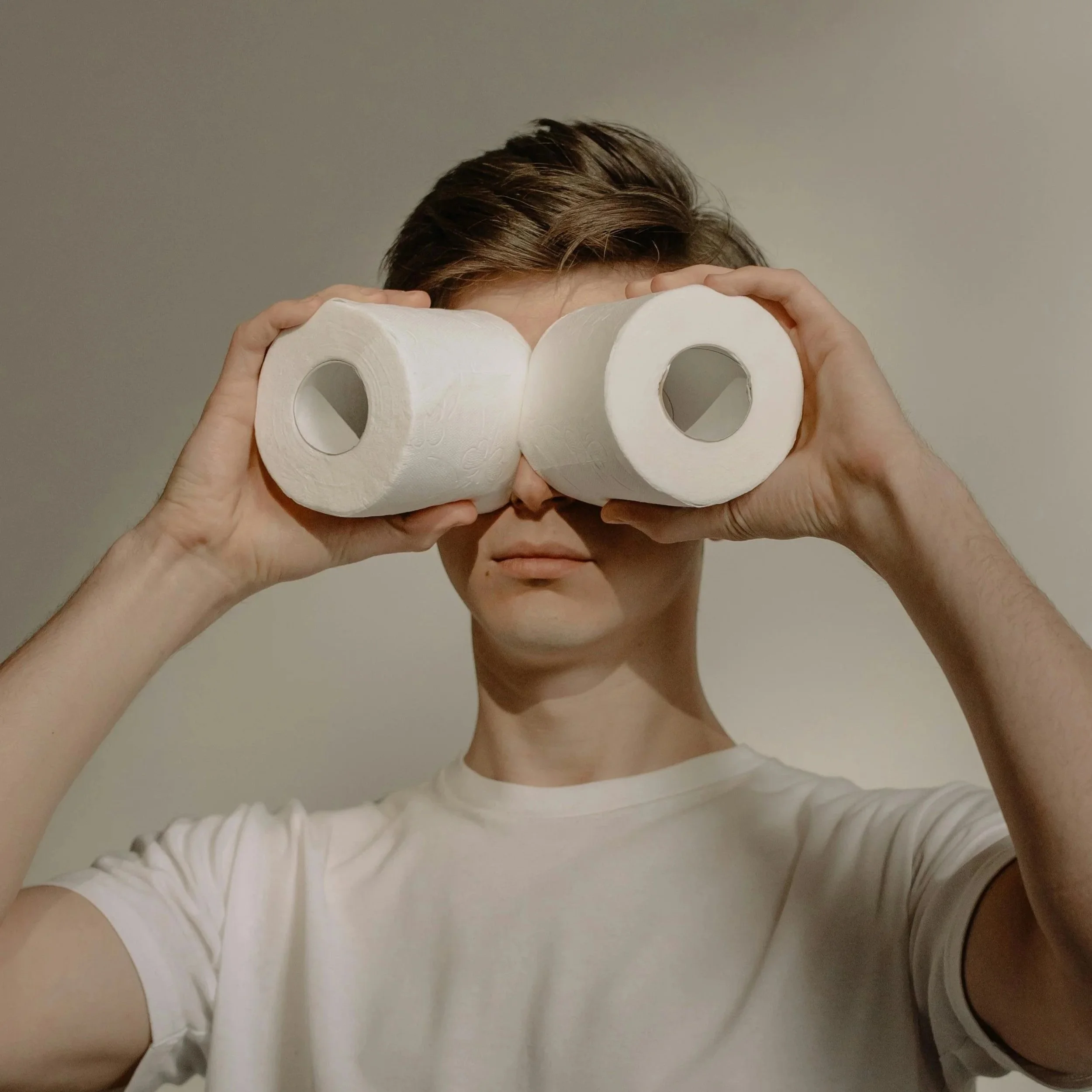 Person holding toilet rolls to eyes as binoculars