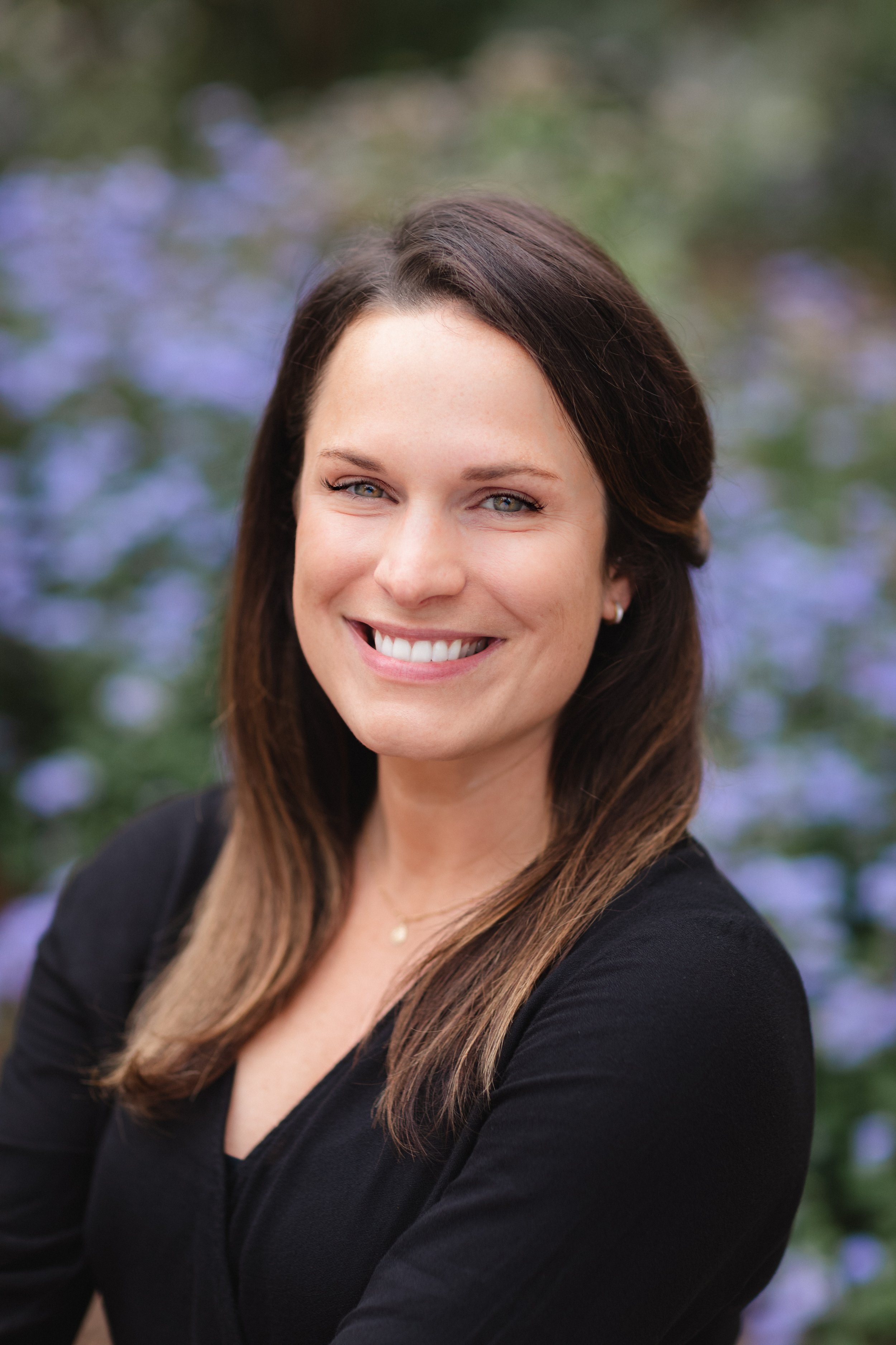 Meet Dr. Hannah Fox, a female presenting person with medium long brown hair. Dr. Hannah is wearing a black shirt and a short silver necklace.