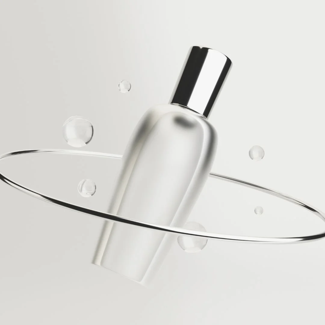 A clear glass bottle with a reflective silver cap, partially submerged in water with water droplets around it.