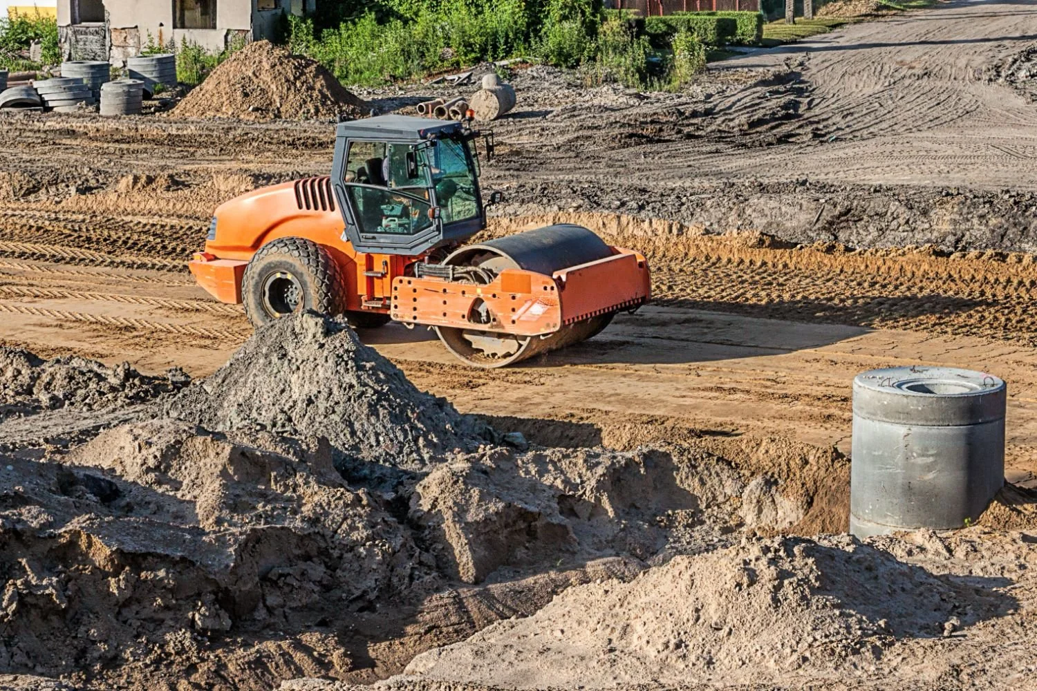 orange truck compressing and leveling alaskan land for site prep