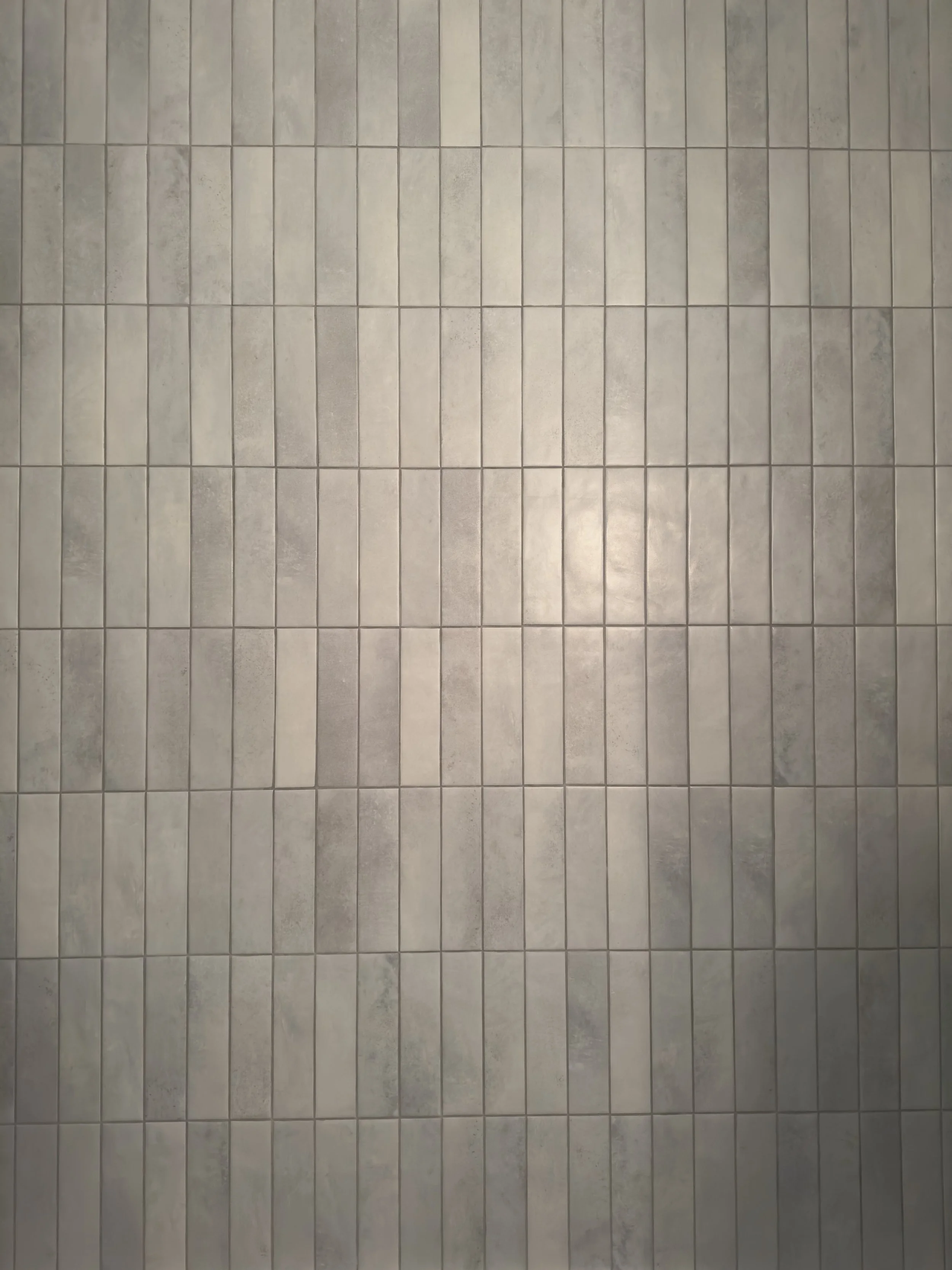 Vertical rectangular tiles in light gray shades forming a pattern.