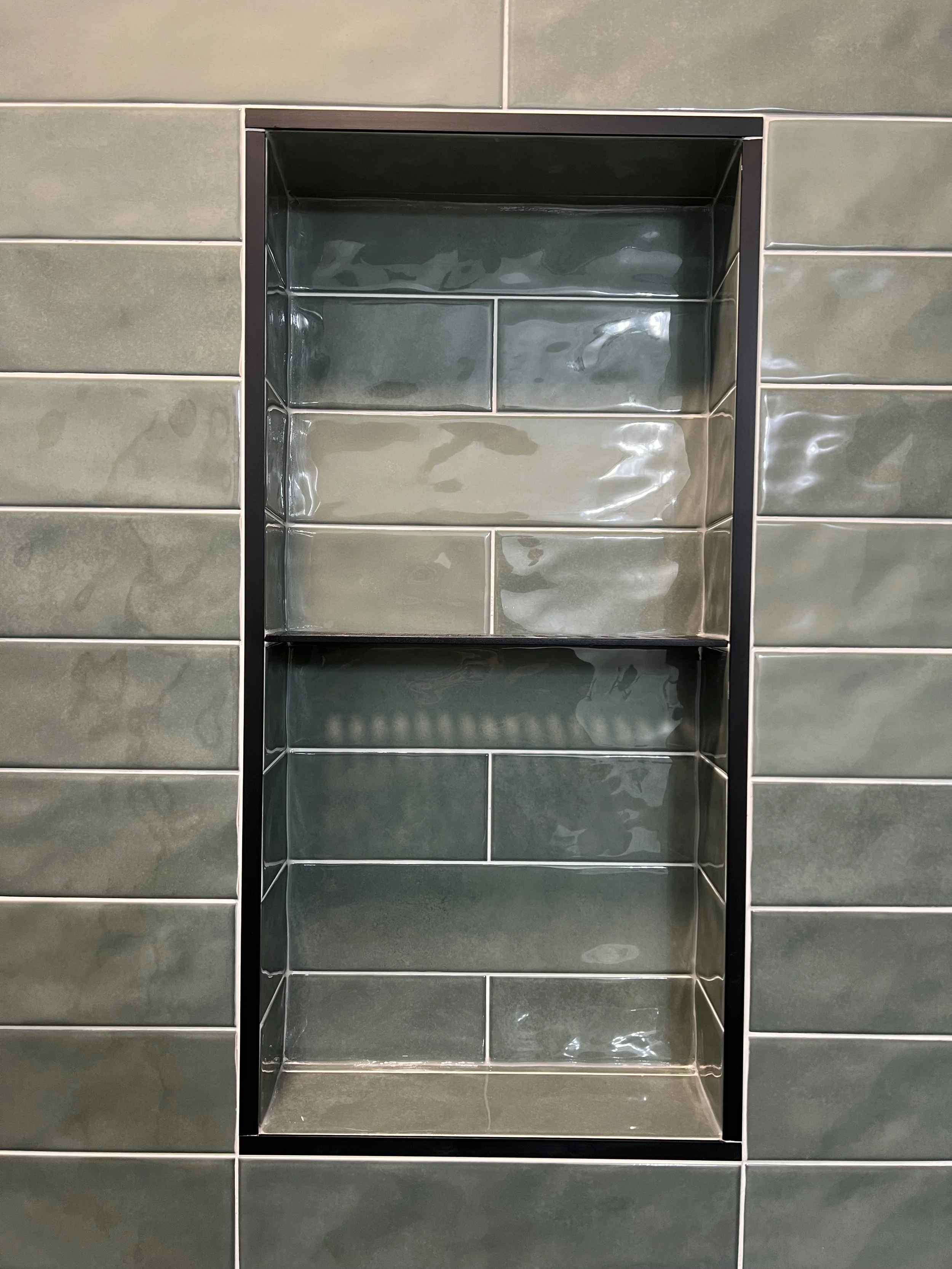Green tile shower niche with shiny finish