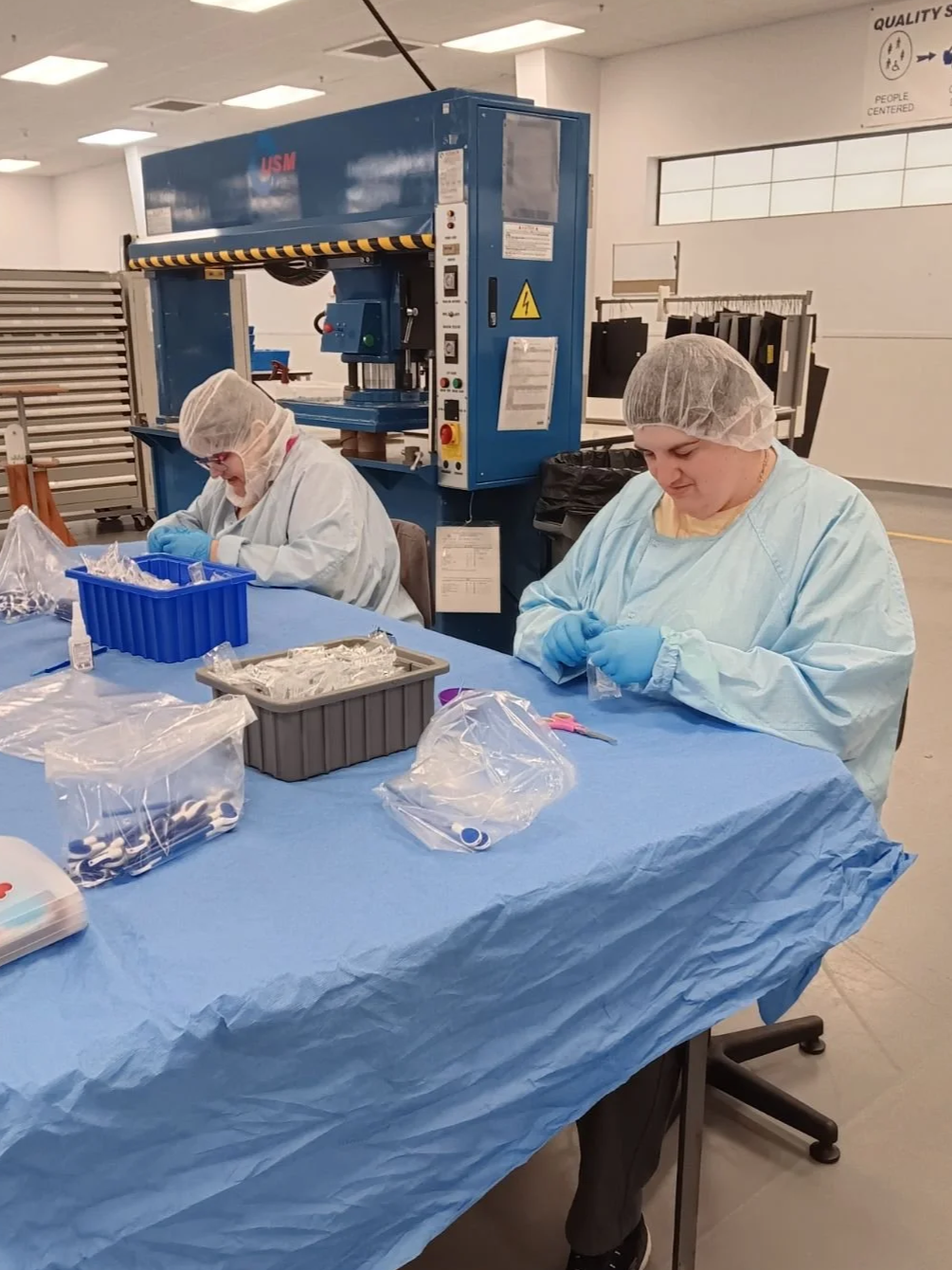 Two HVO employees carefully assembling and packaging medical devices, ensuring compliance with quality and regulatory standards.