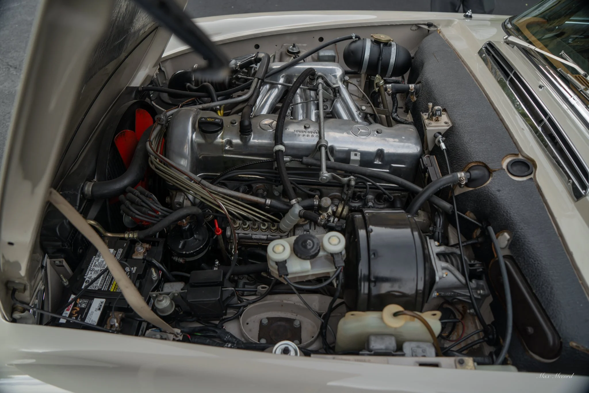 Photo of a vintage Mercedes-Benz car engine in the engine bay.