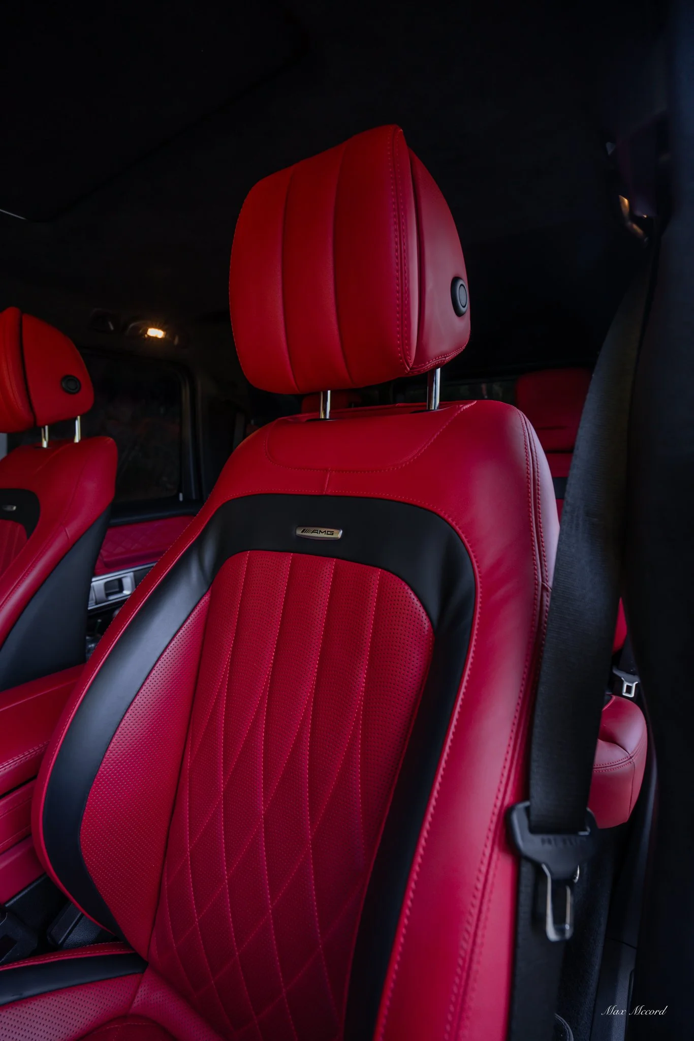 Red leather car seats with black accents in a luxury vehicle.