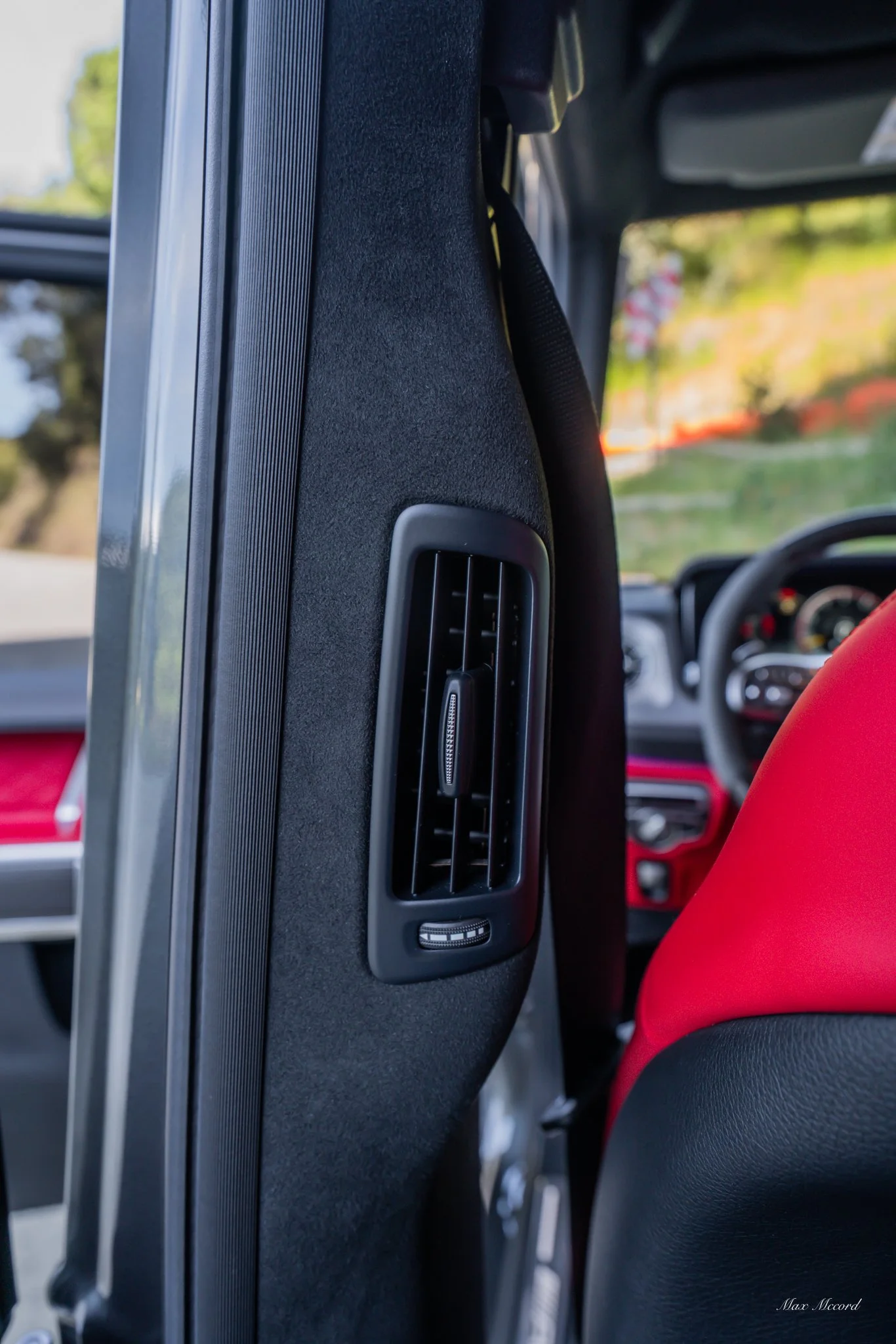 Close-up of a car's interior showing the side air vent and part of the dashboard.