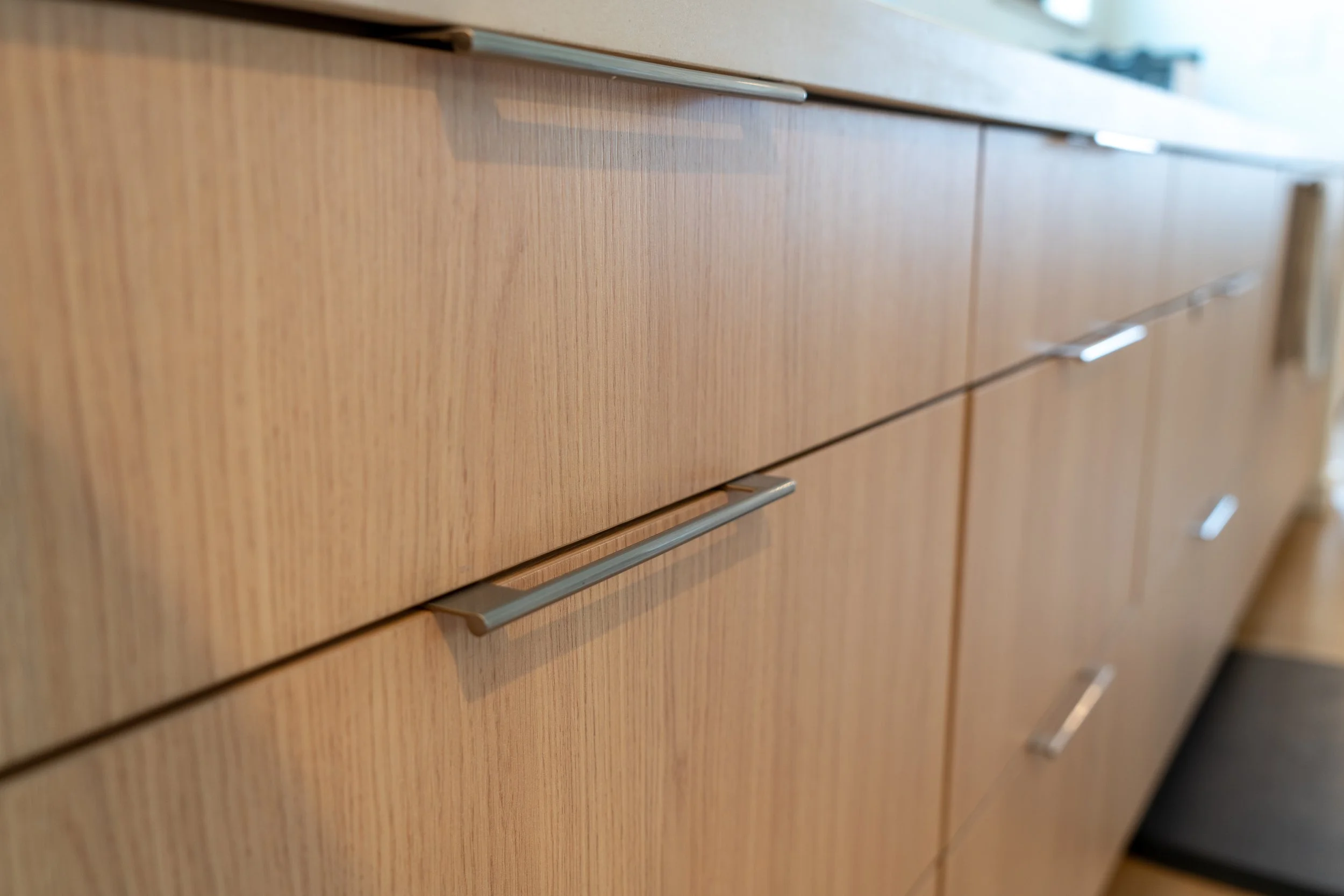 Close-up of a wooden kitchen cabinet with metal handles.