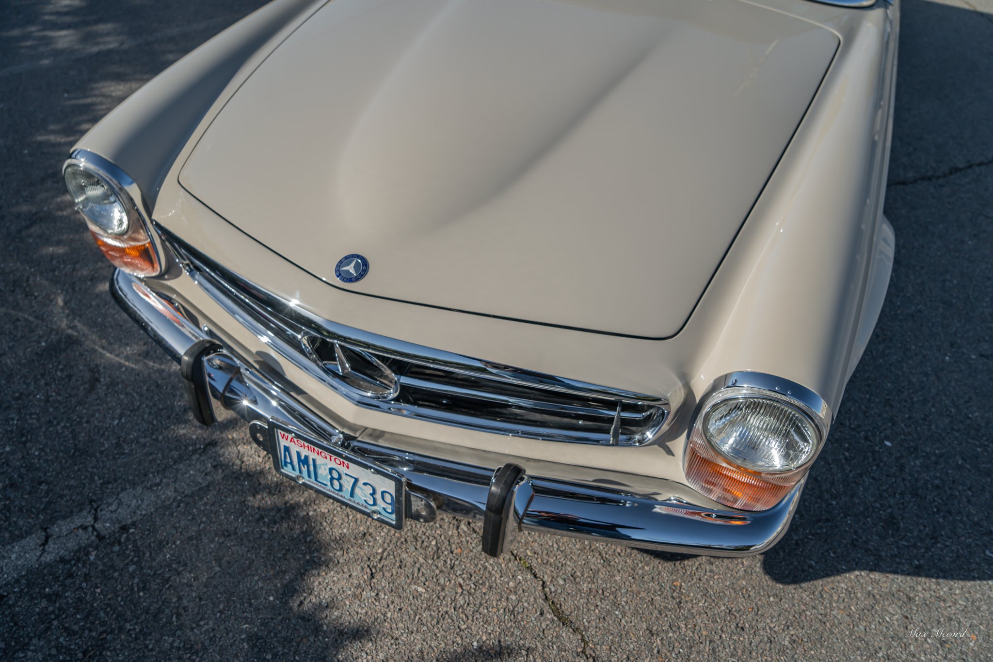 Front view of a vintage cream-colored Mercedes-Benz car with a Washington license plate, chrome grille, and round headlights.