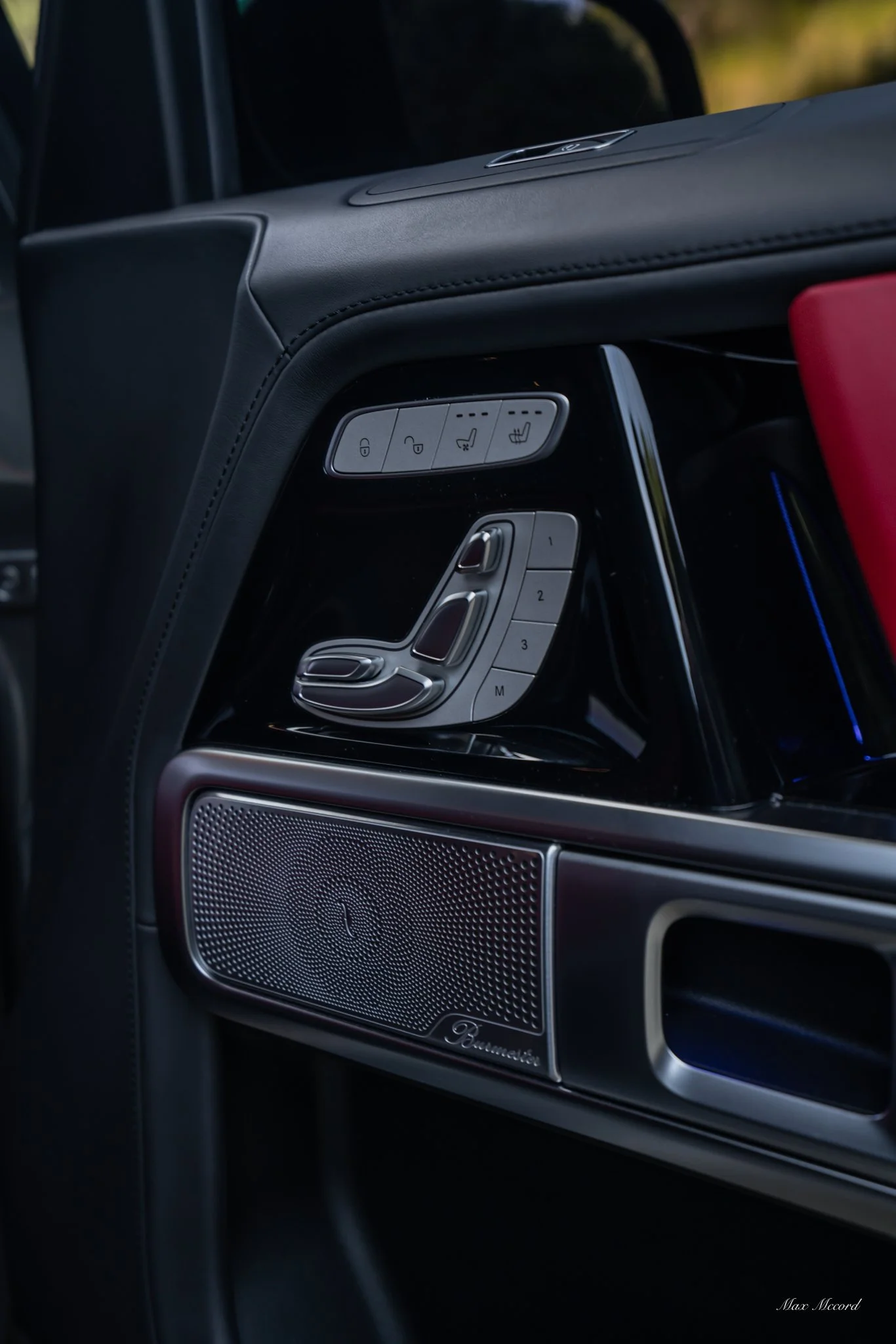 Close-up of a luxury car's interior dashboard featuring seat adjustment controls, speaker grille, and seat heating buttons.
