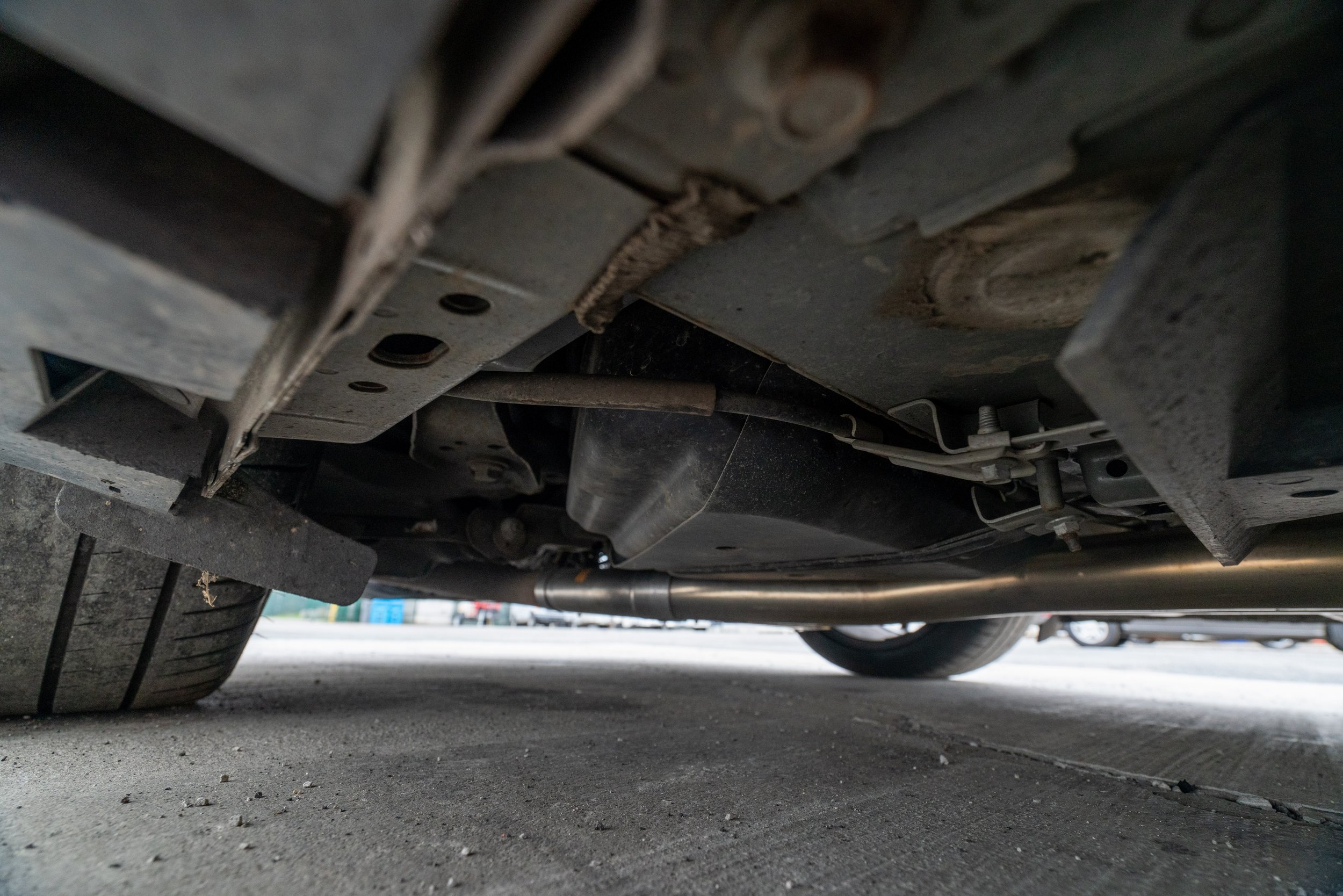 Under the car showing the exhaust pipe and parts of the undercarriage.