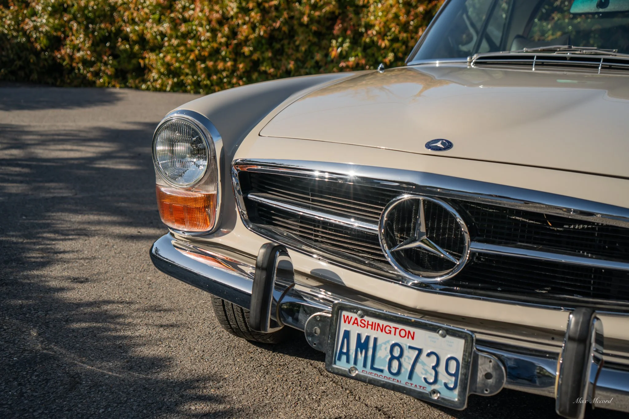 Close-up of the front of a vintage beige Mercedes-Benz car with a Washington license plate 'AML8739.'