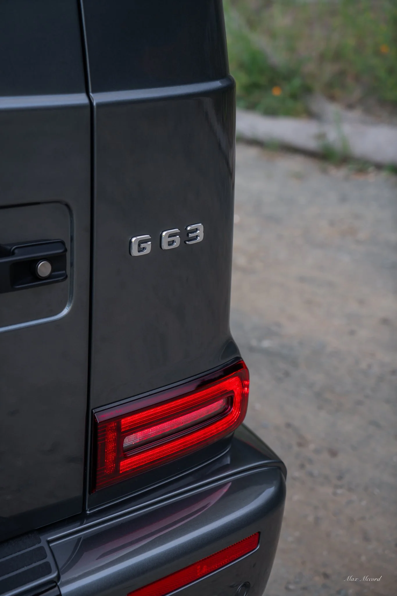 Close-up of the rear end of a black Mercedes-Benz G63 luxury SUV, showing the model badge and rear tail light.