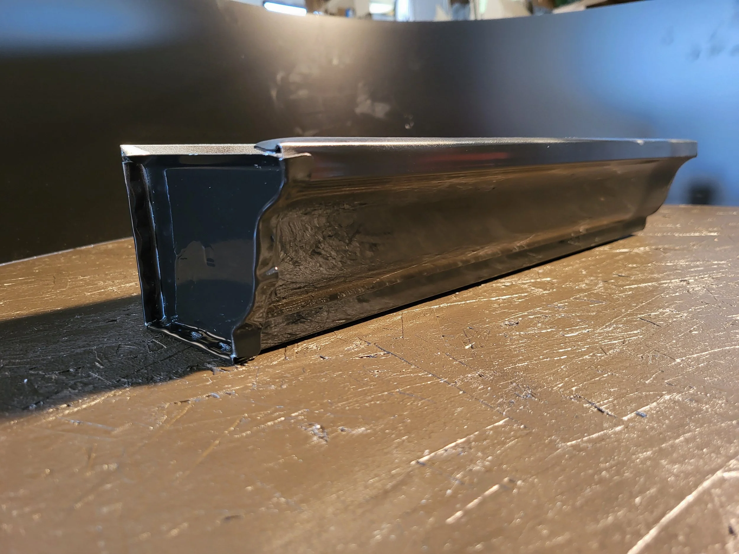 Close-up of a Black 5k Gutter showing the endcap