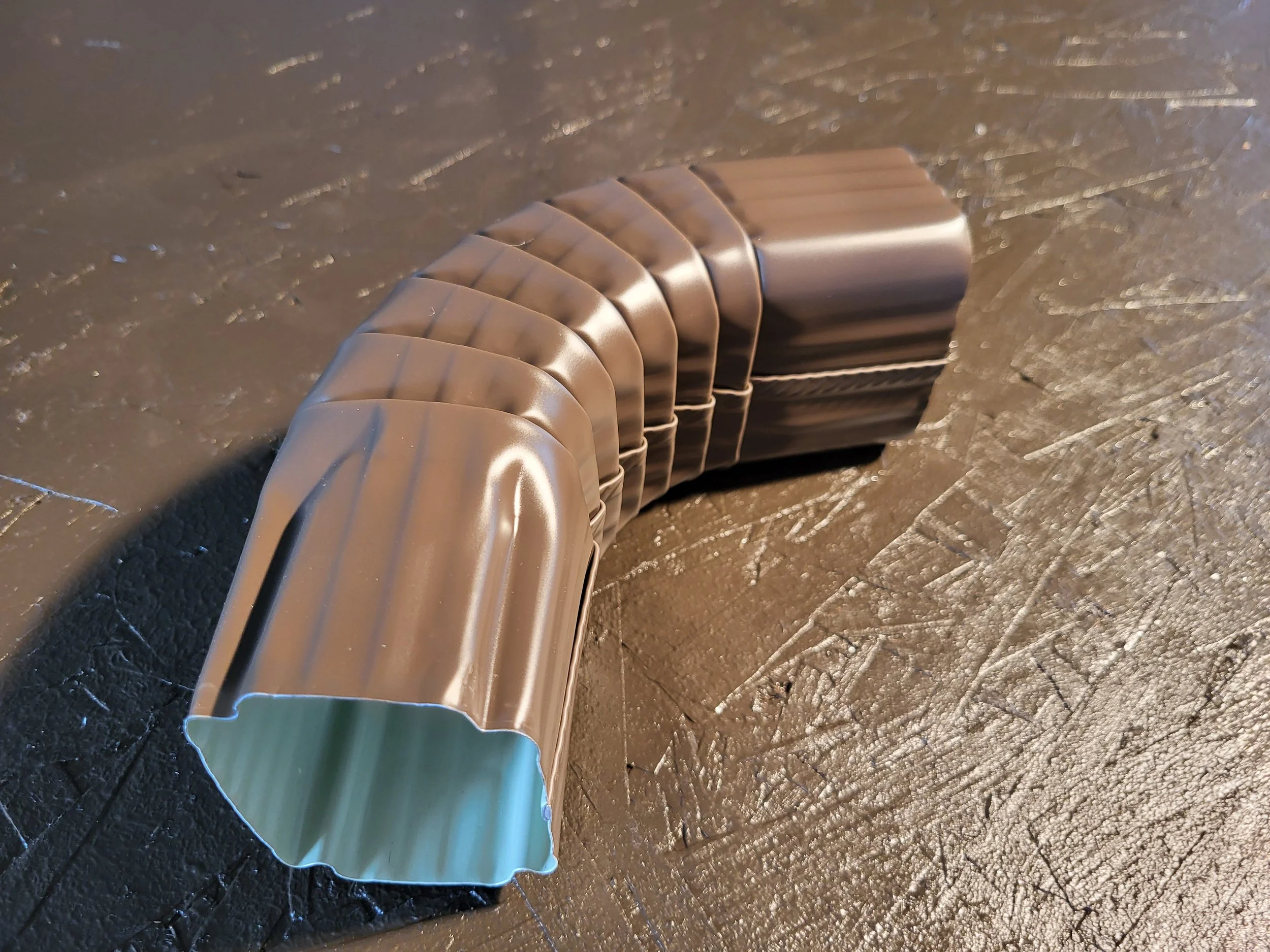 a brown corrugated 2x3 inch downspout elbow