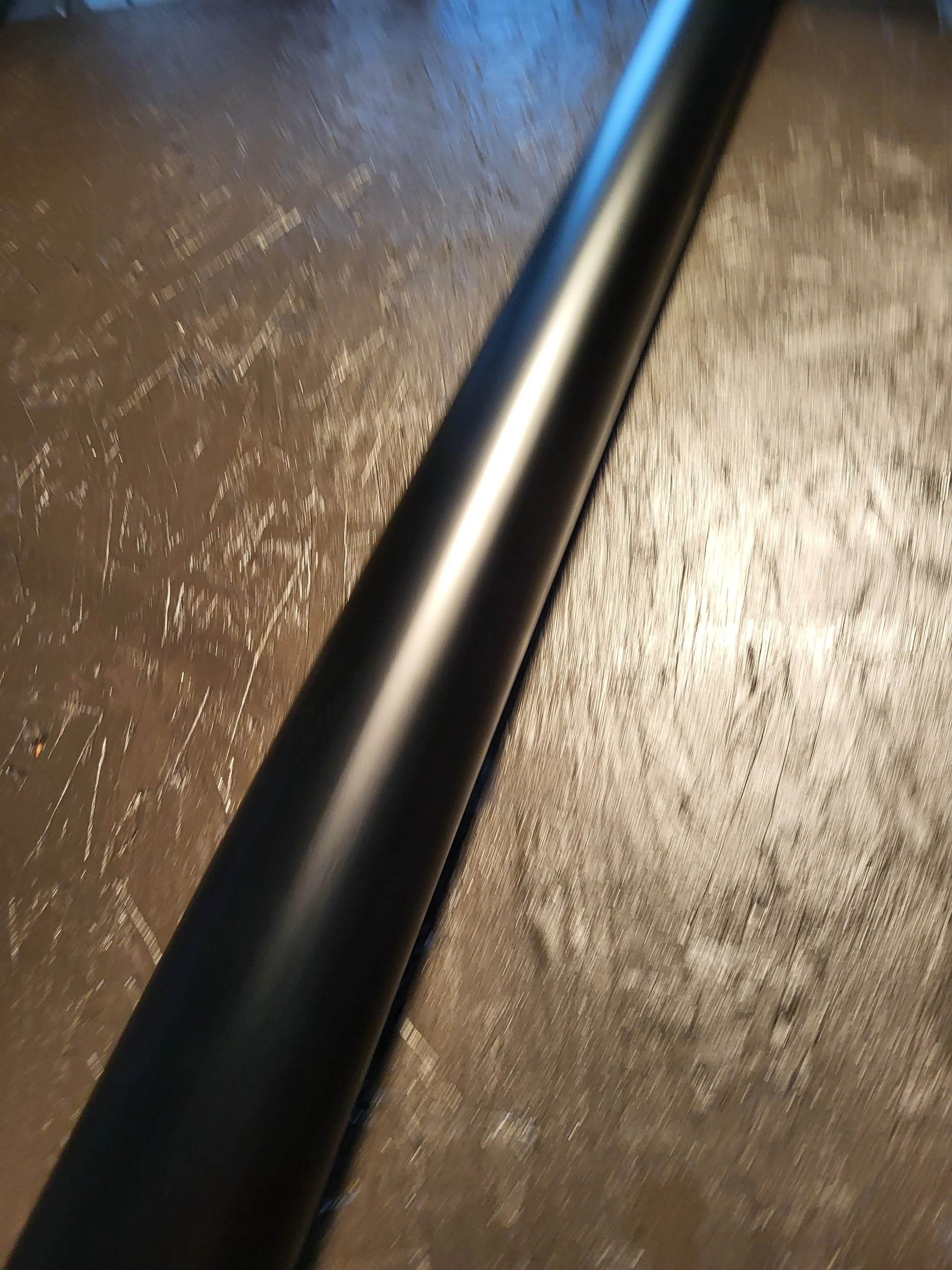Close-up photo of a black metal round downspout.