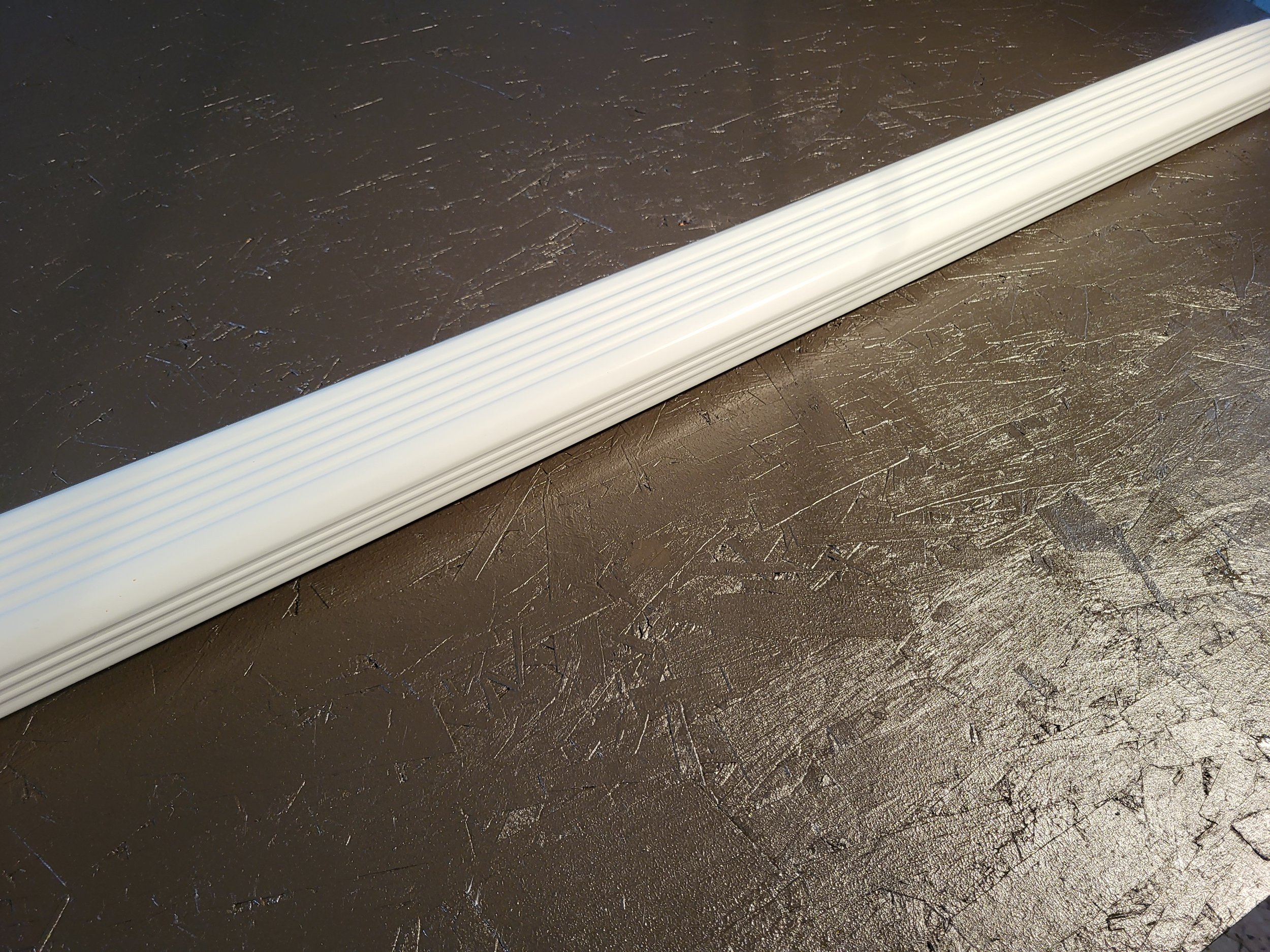 Close-up of a white 2x3 inch aluminum corrugated downspout