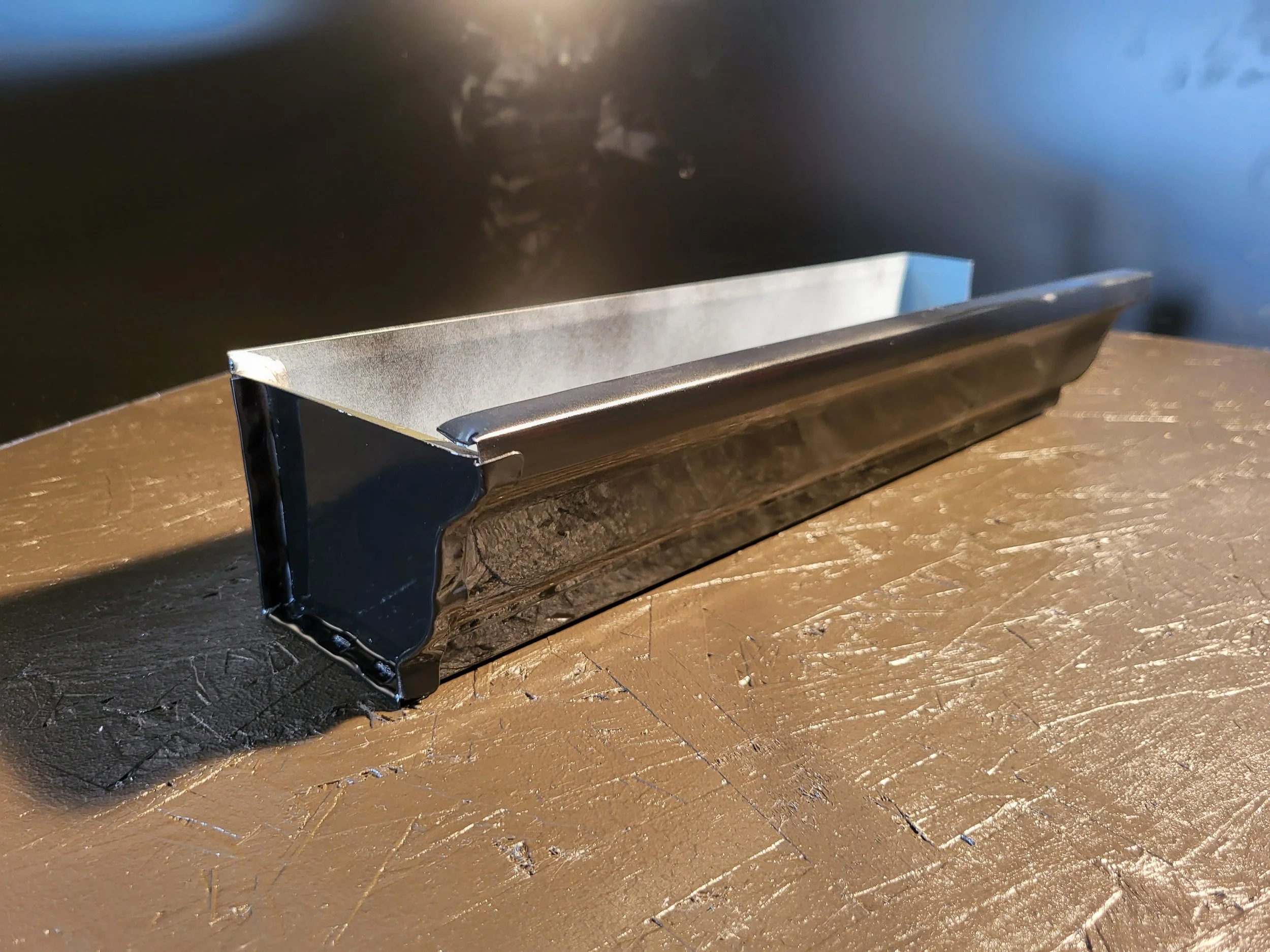 Close-up of a black aluminum 5k gutter