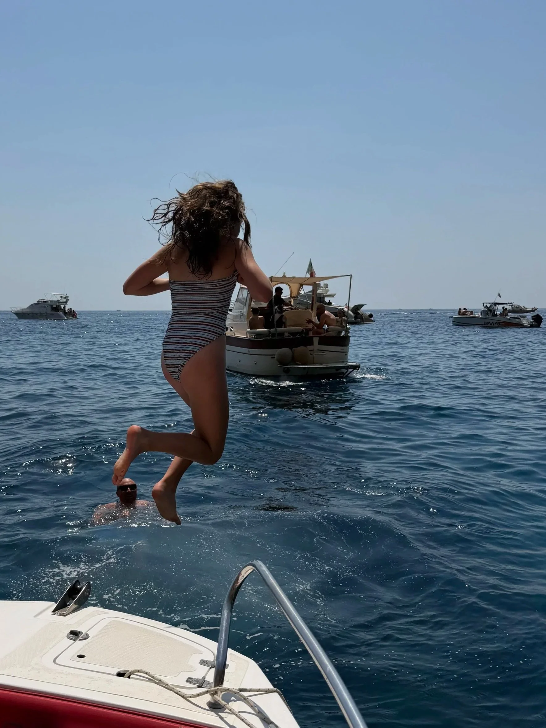Girl jumping off a boat in the Almafi Coast.