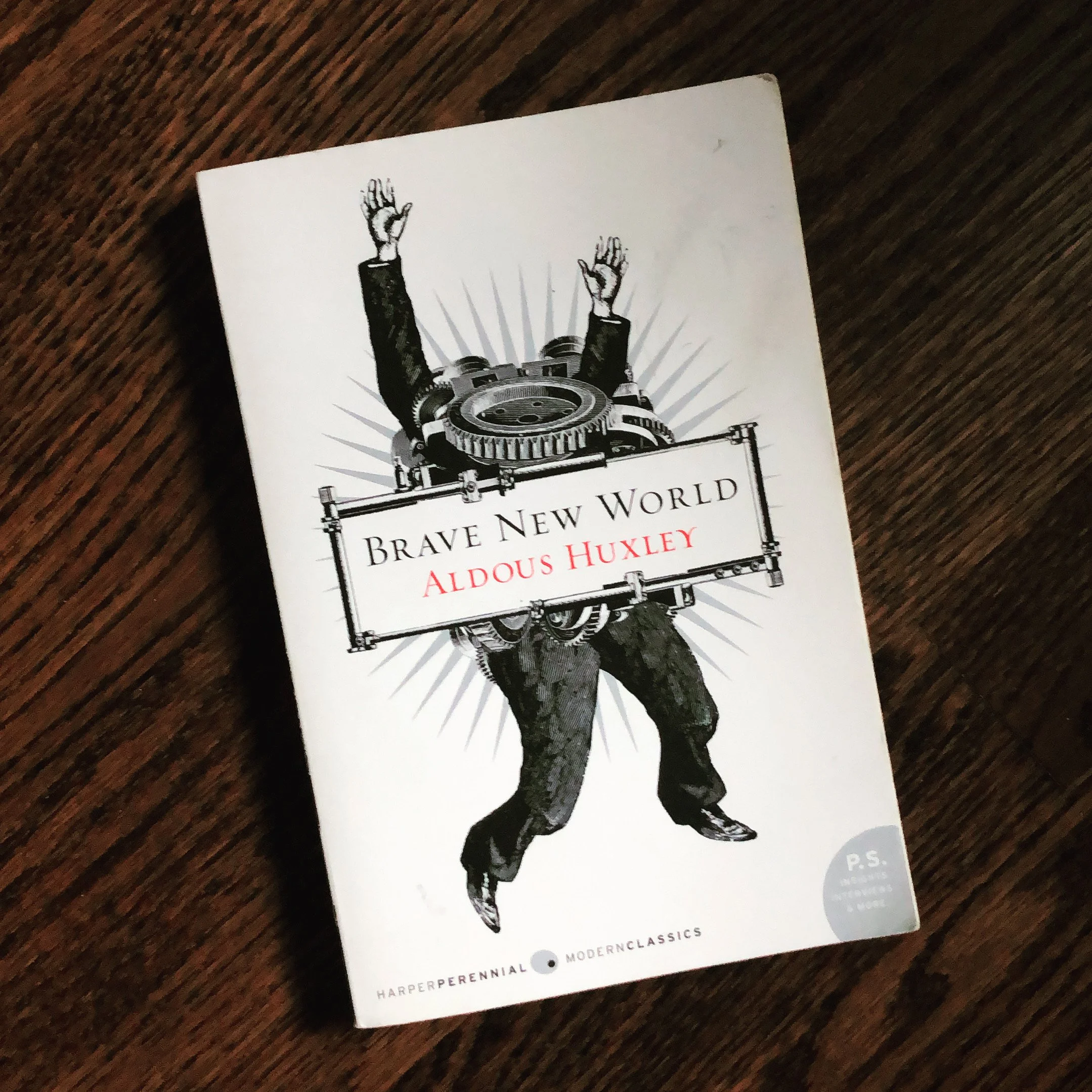 The book Brave New World by Aldous Huxley on a wood background