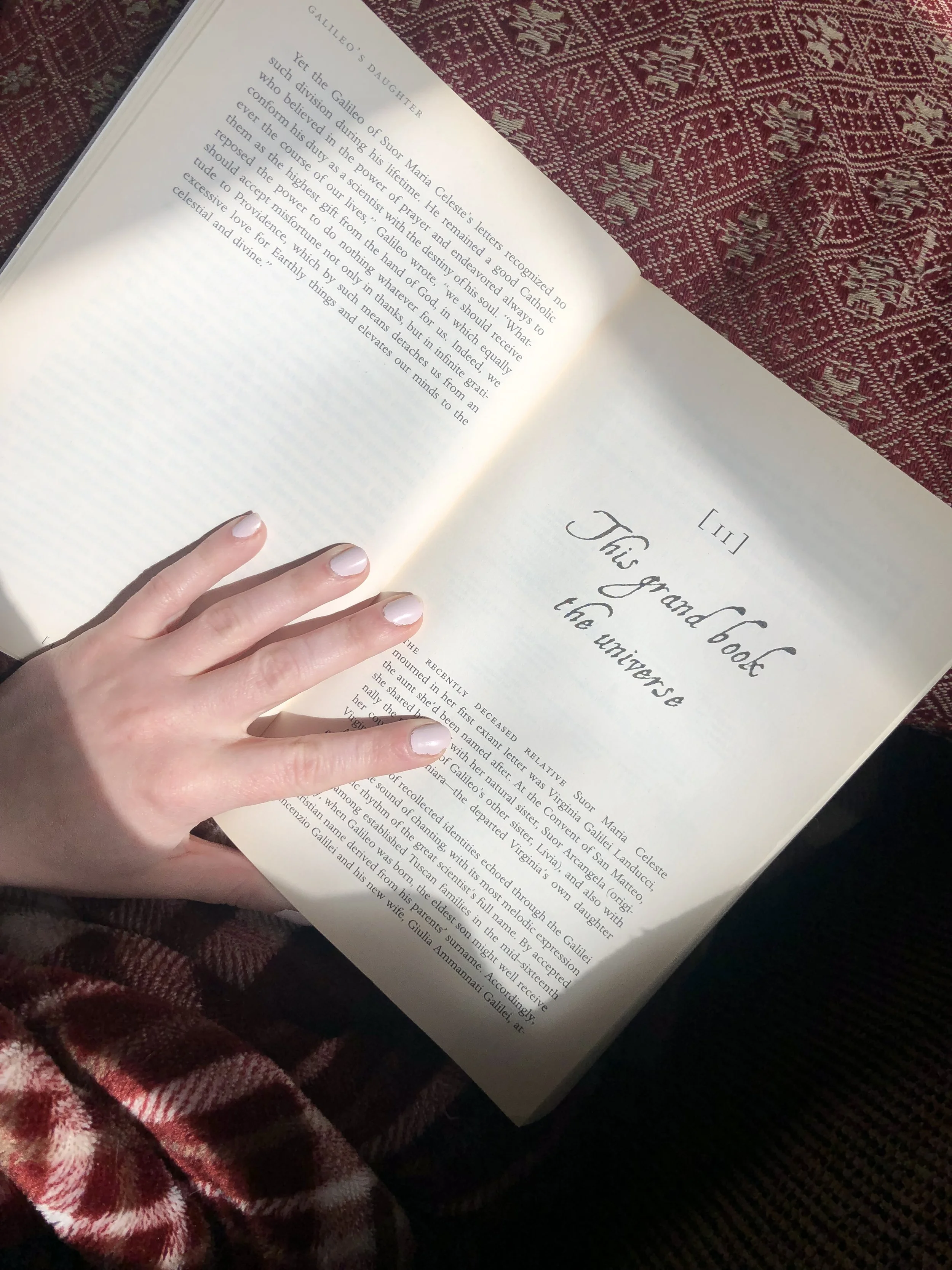 hand holding open a book showing the page and chapter title