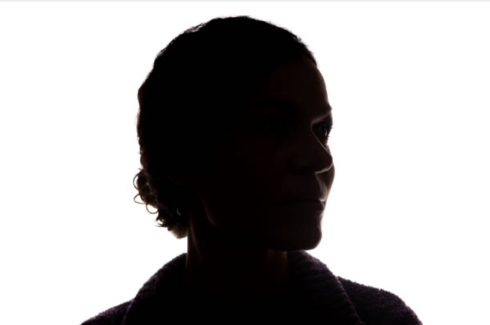 Silhouette of a person's profile facing right, with short, curly hair, against a bright background.