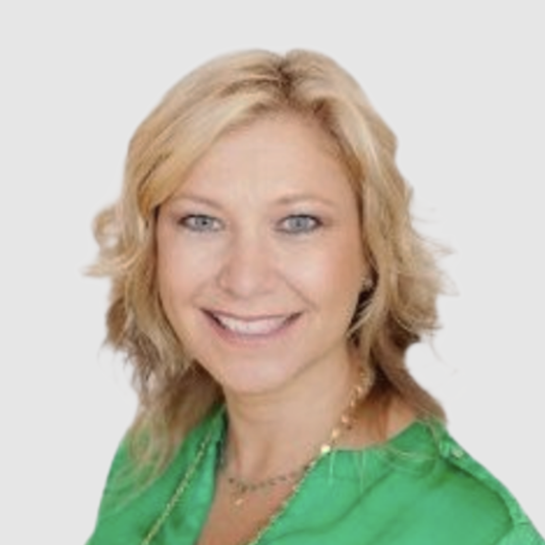 A smiling woman with blonde hair wearing a green blouse and a gold necklace.