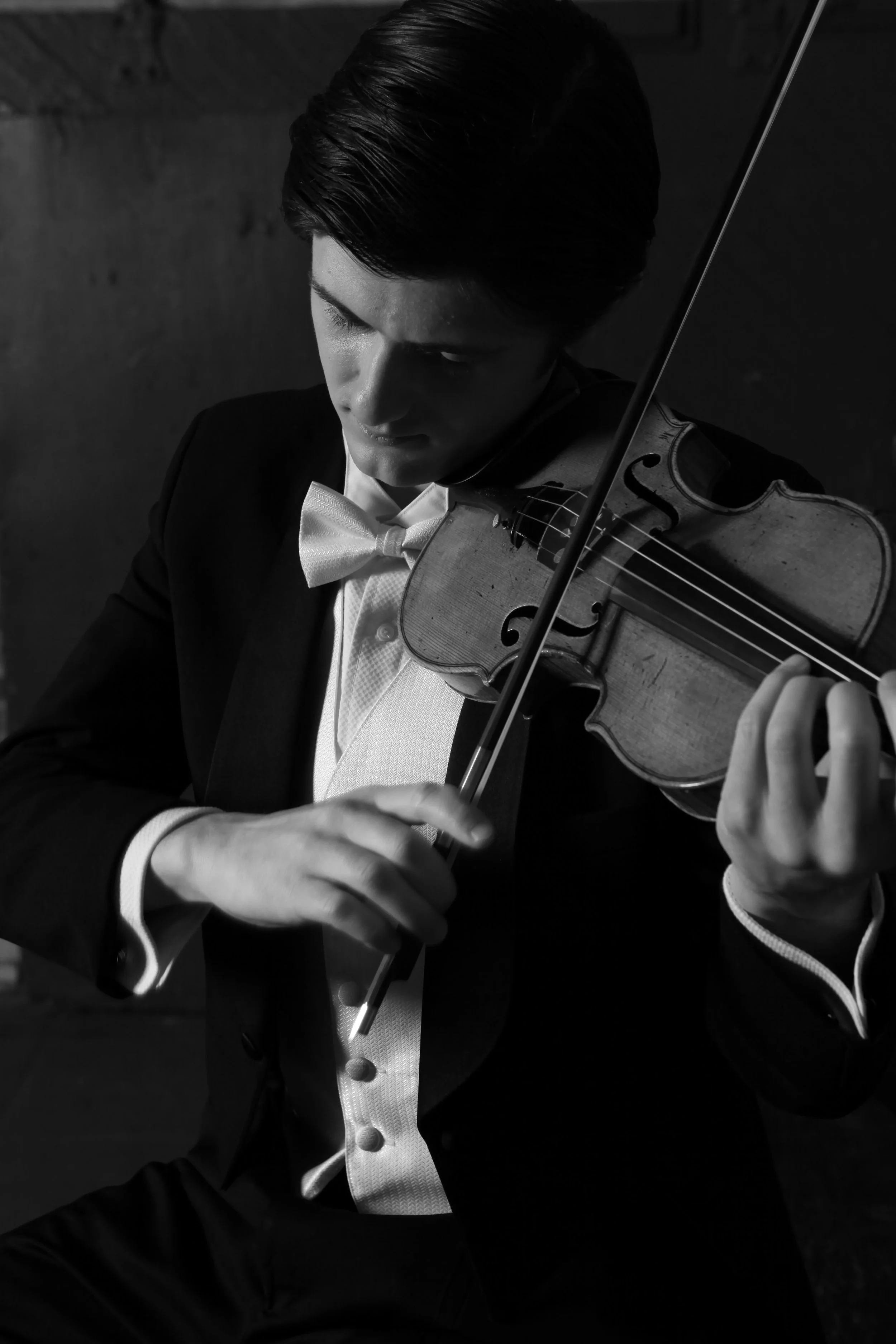 A man in a tuxedo playing the violin.