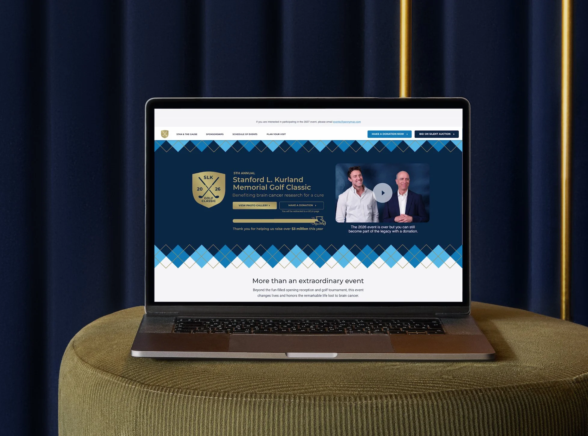 A laptop on a round, green ottoman with a navy blue curtain background. The laptop screen displays a website for the Stanford L. Kurland Memorial Golf Classic, with event details, a video thumbnail, and donation options.
