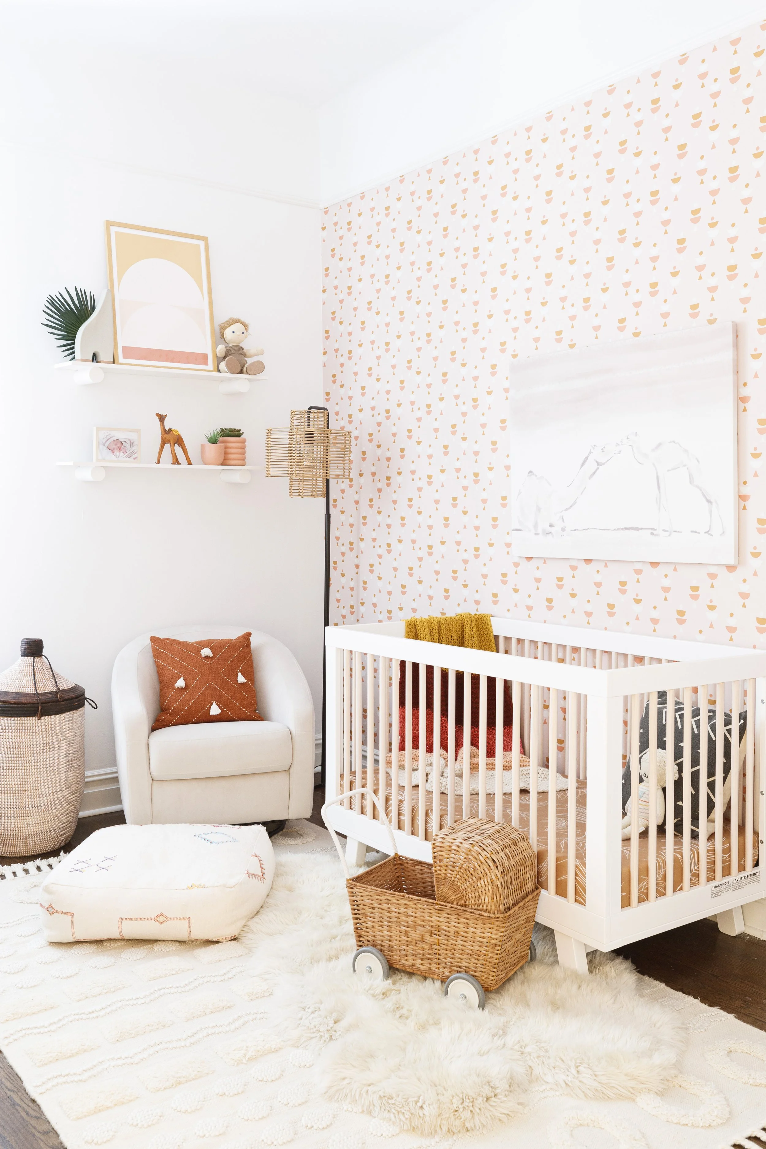 white crib, cream accent chair and rattan accents in modern moroccan themed baby girl nursery designed by Westchester interior decorator Jordana Ross Interiors.