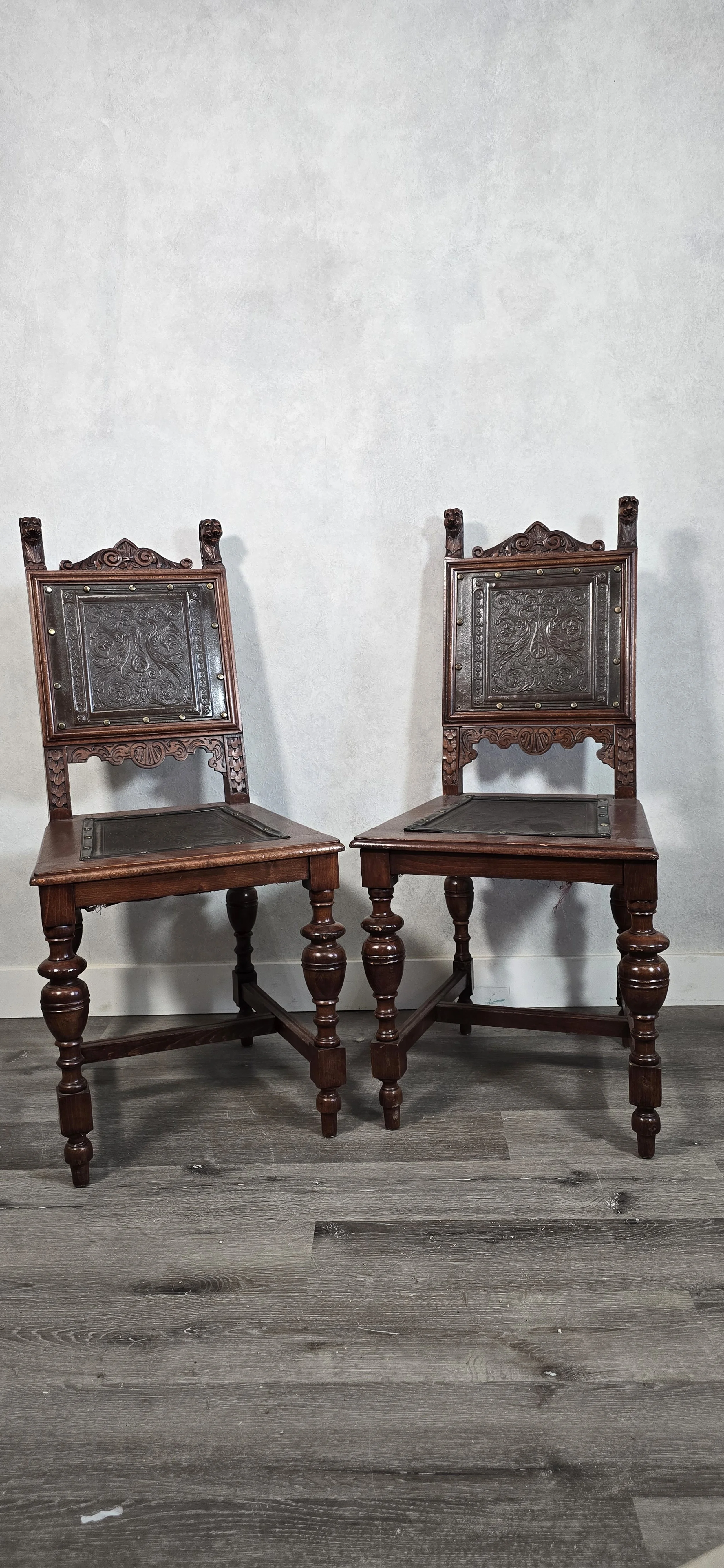 Antique ornately carved wood chairs with embossed leather seats and backs.  No markings found on them.   $325 each