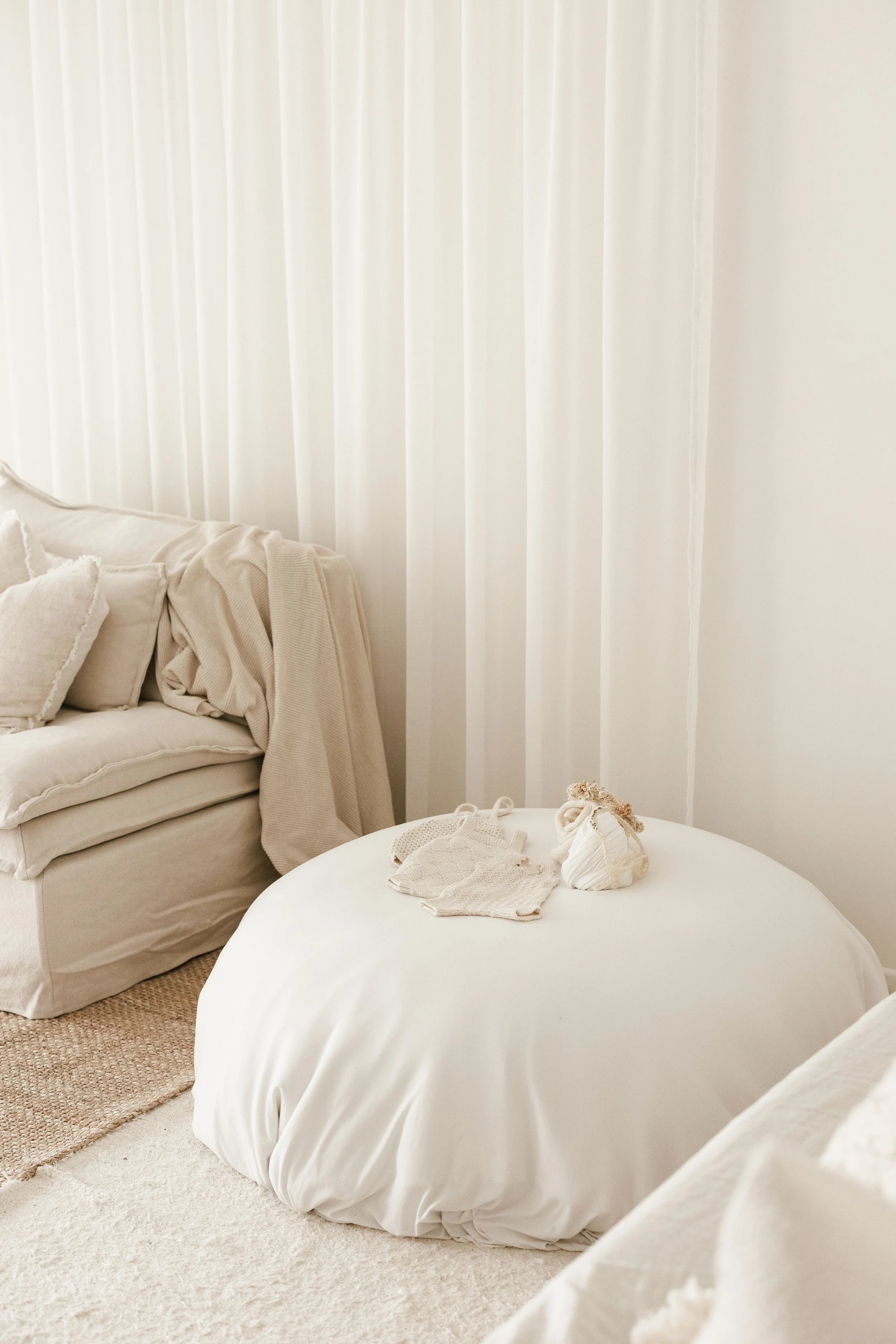 newborn baby outfits on a bean bag in a studio