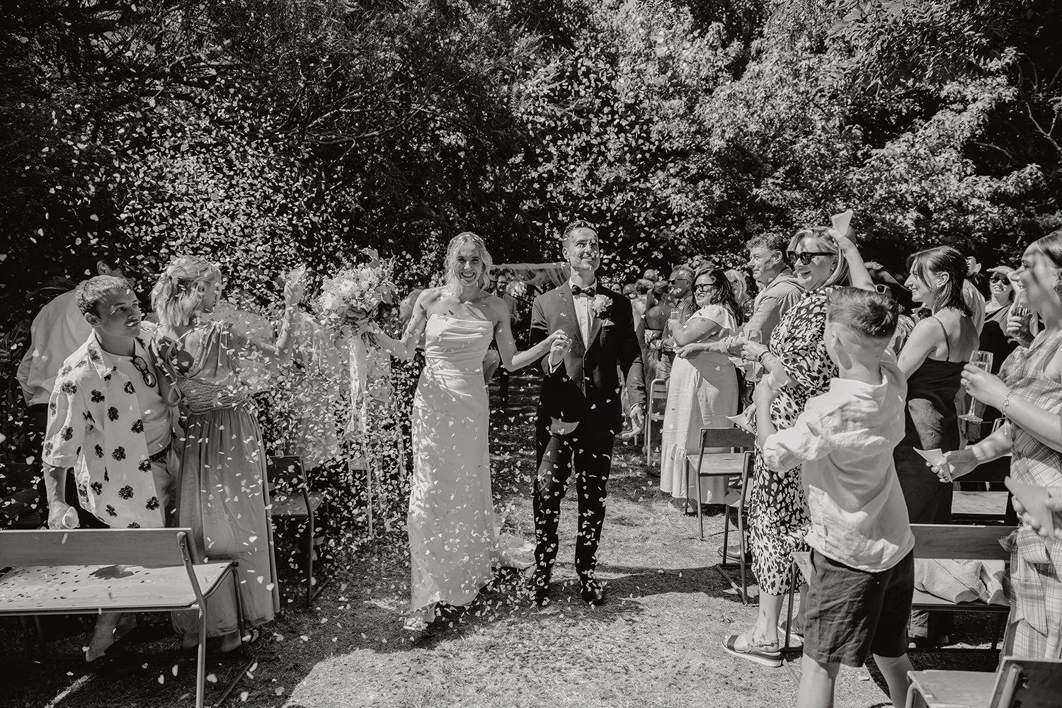 bride & groom walking down aisle with confetti thrown in the air