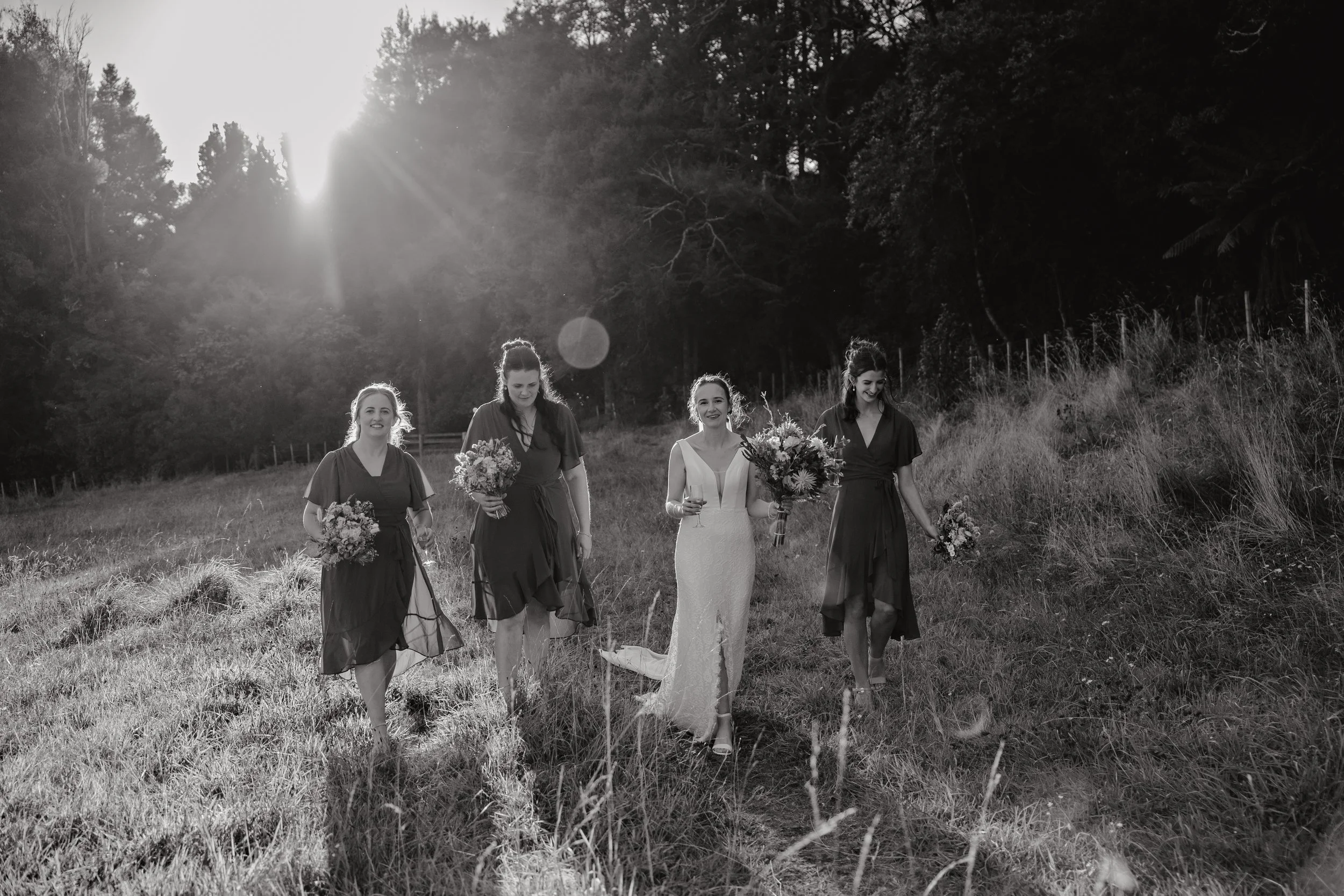 Taupo wedding photographer, Bridesmaids walking in long grass, Taupo weddings