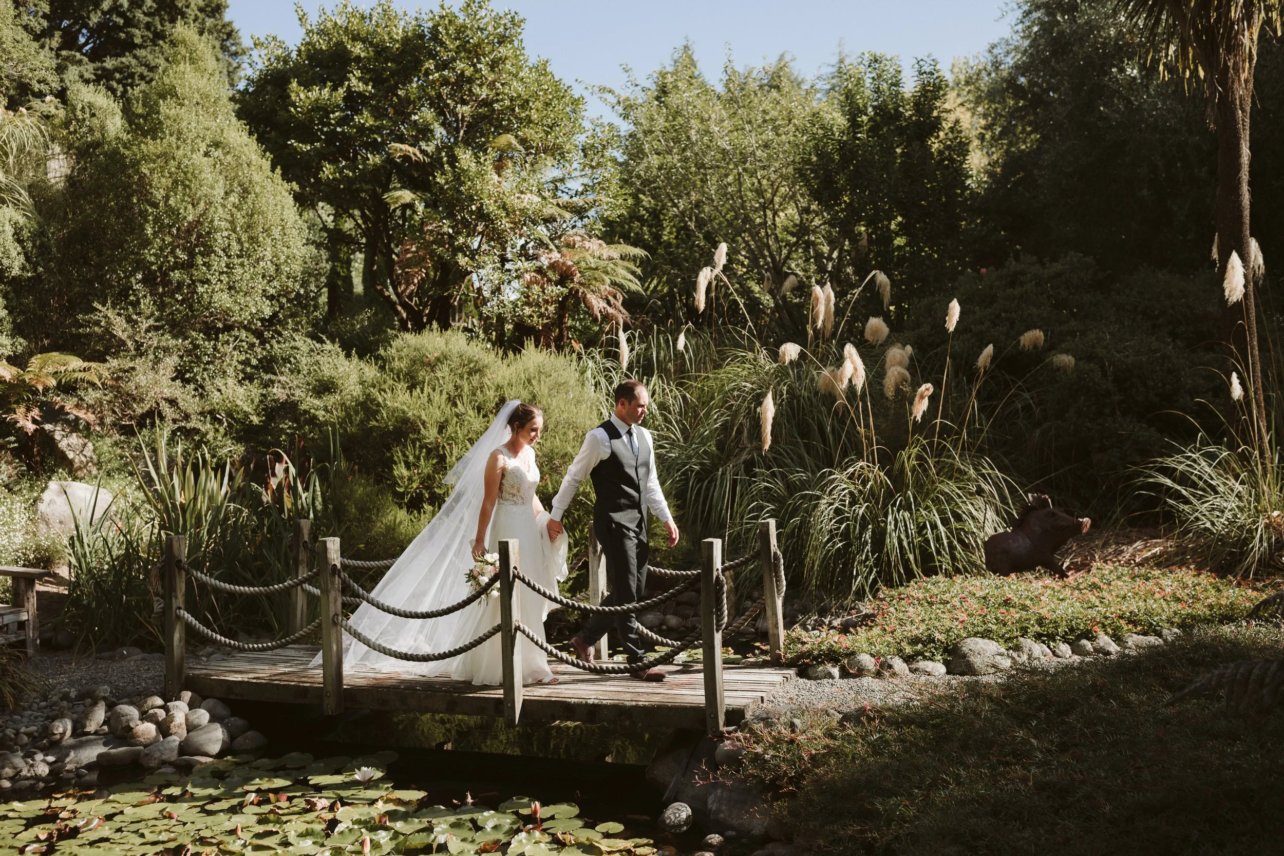 Black Barn Wedding, Bride & Groom walking on bridge, Taupo weddings