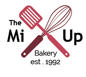 Logo with a spatula and whisk crossed above the text 'The Mi Up Bakery est. 1992'.