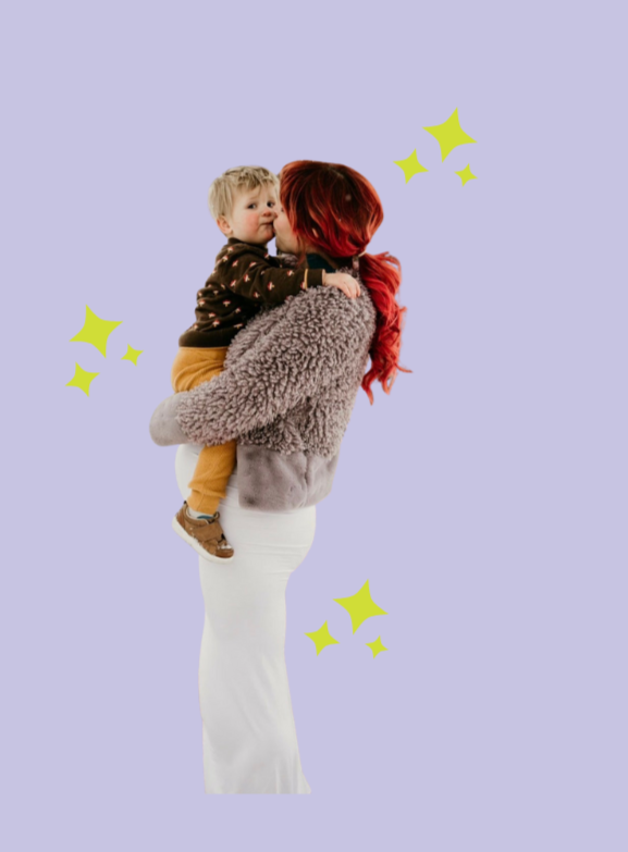 A woman with red hair holding a young child with blond hair on her shoulder, against a light purple background with yellow star illustrations.