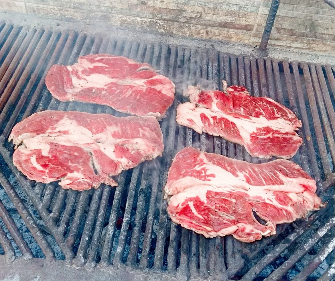 Raw beef steaks on a grill, ready to be cooked.