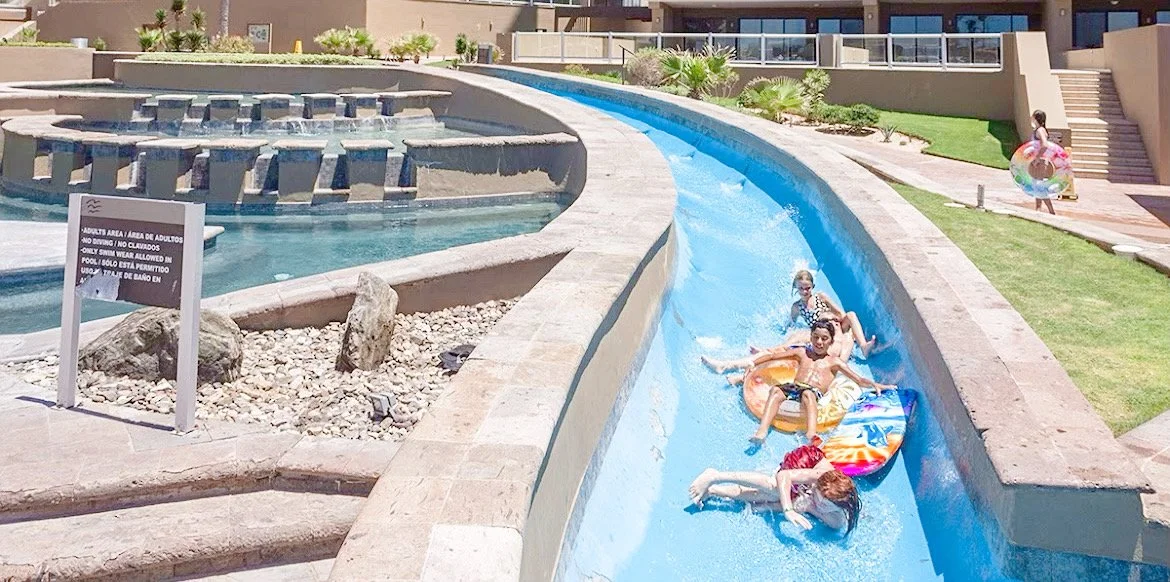 People relaxing on inflatable tubes in a water park lazy river.
