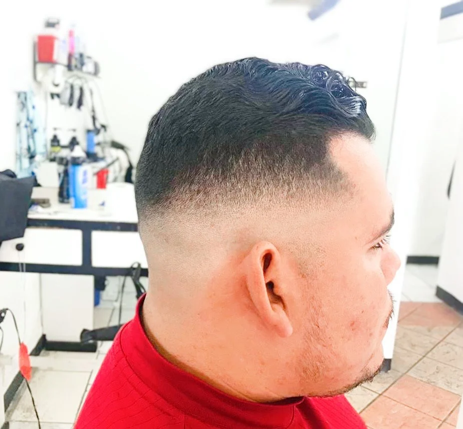 Man with a fresh fade haircut in a barbershop.