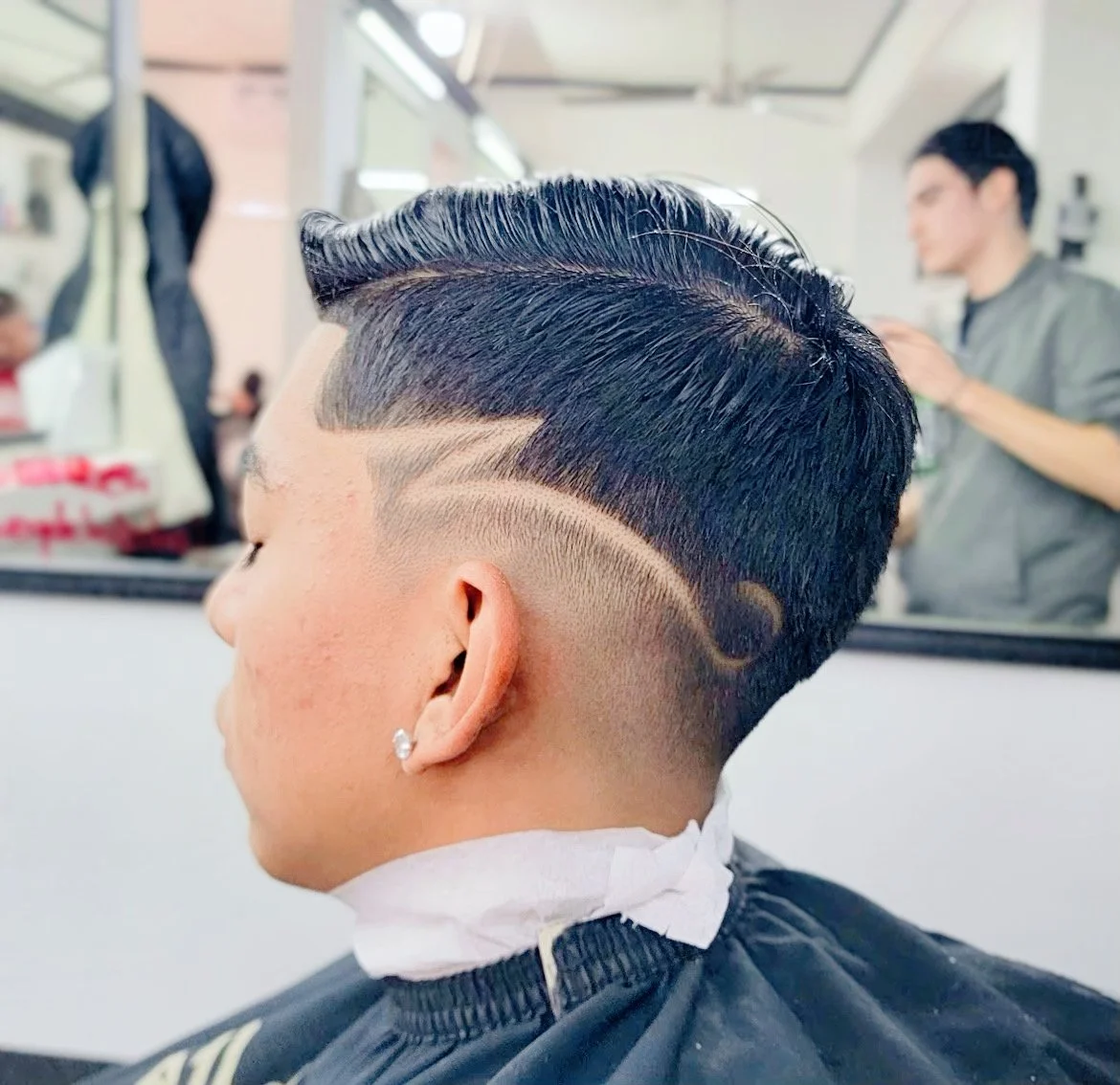 Man with a stylish undercut and geometric hair design in a barbershop