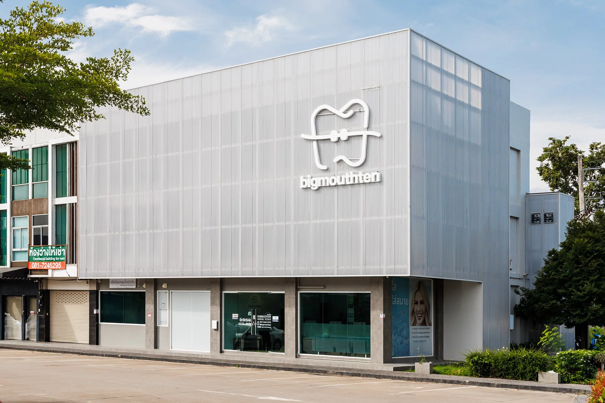 Exterior view of Bigmouthten Dental Clinic building in Chiang Mai with spacious parking area