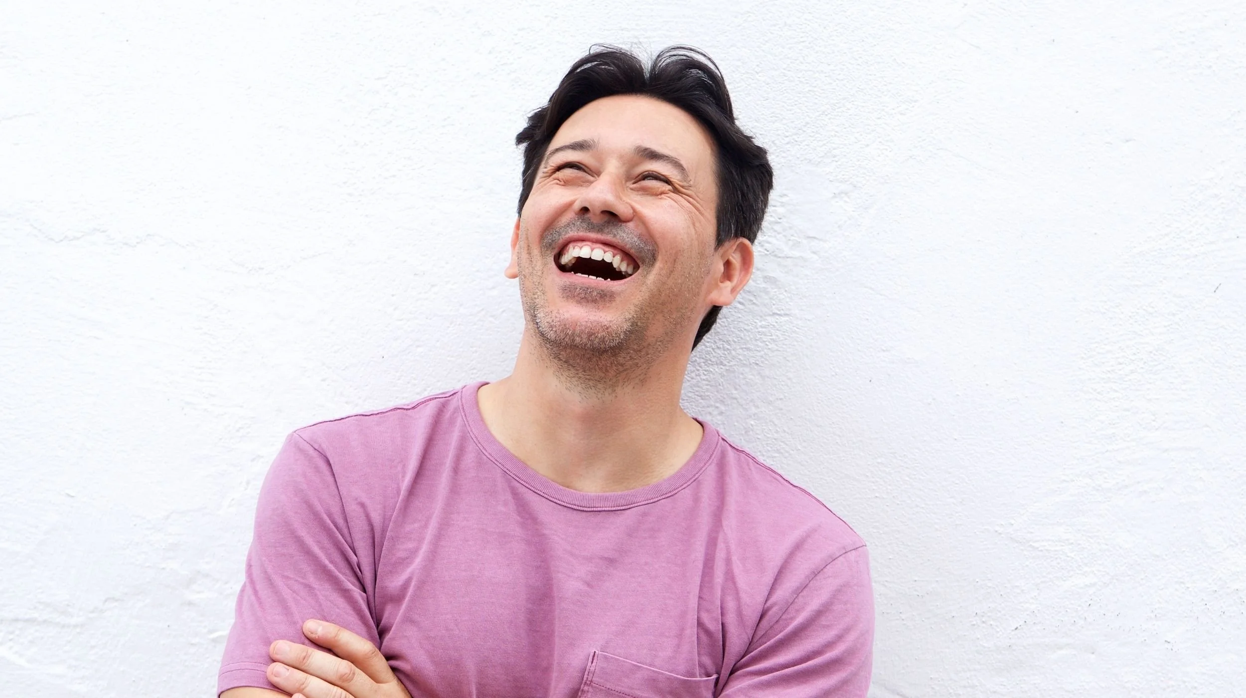 A smiling man enjoying his daily life with stable and functional fixed dental implants, providing a natural look and feel.