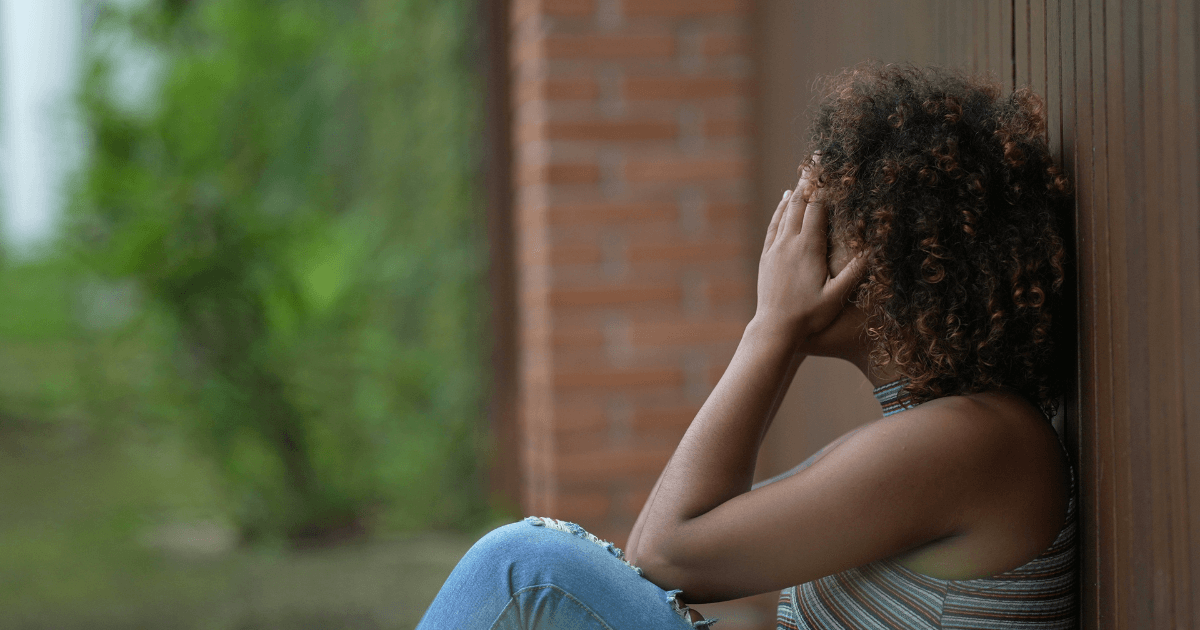 A sad woman with her head in her hands experiencing christian counseling for shame.