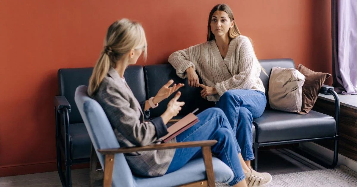 A woman asking what is Christian therapy from her psychologist in an office building.