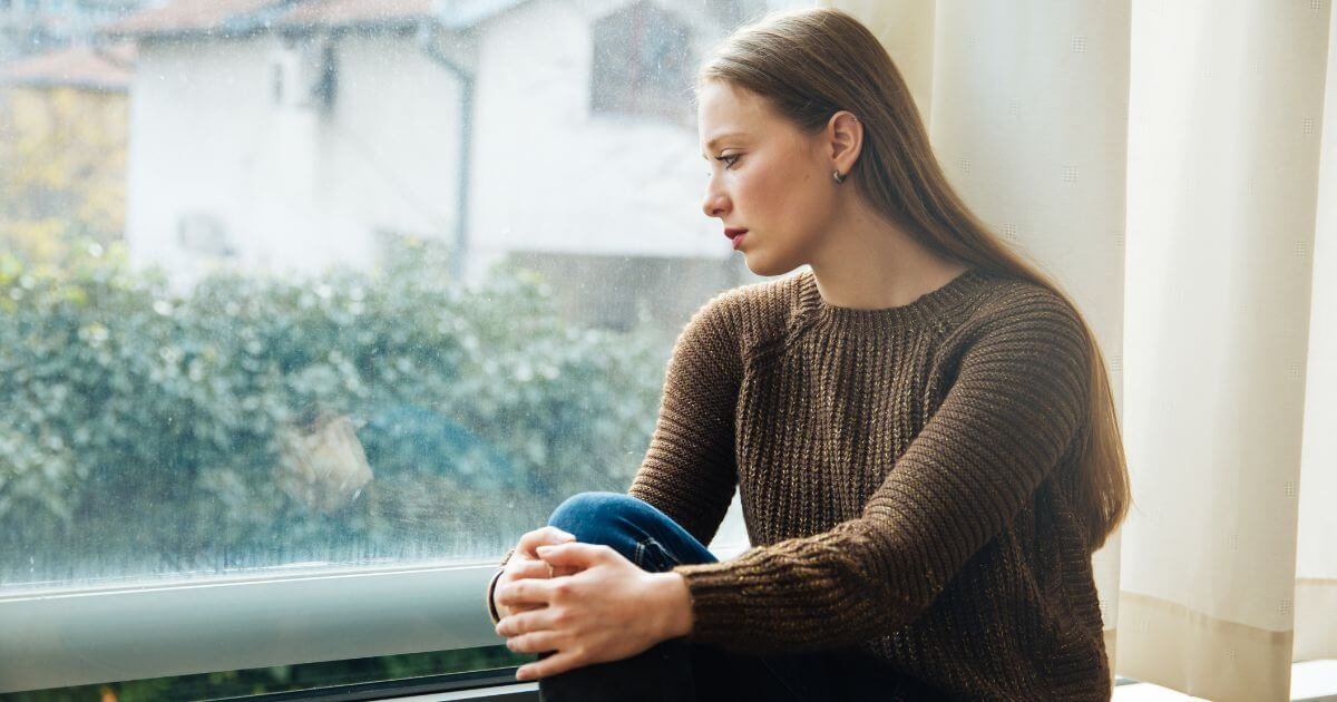 A woman looking out a window faith and neuroscience.