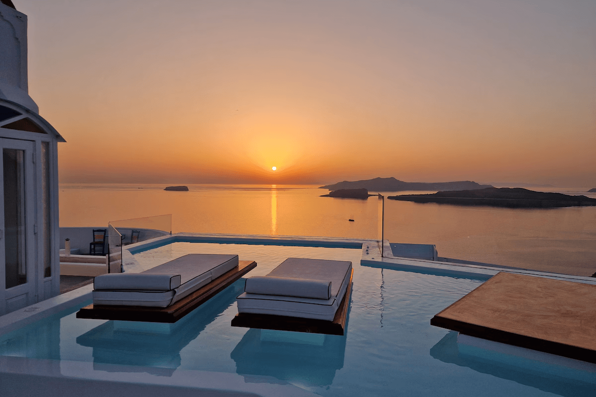 Overflow pool with panoramic caldera views at sunset at Private Villa near Megalochori, Santorini